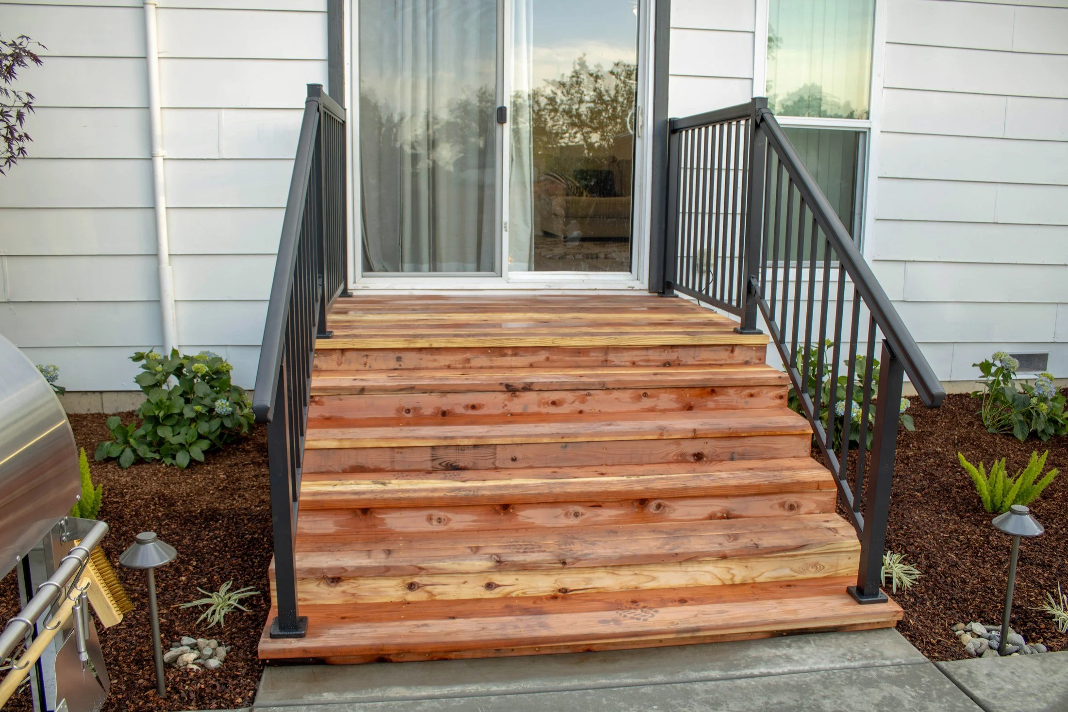 New cedar steps connect the home to the redesigned backyard.