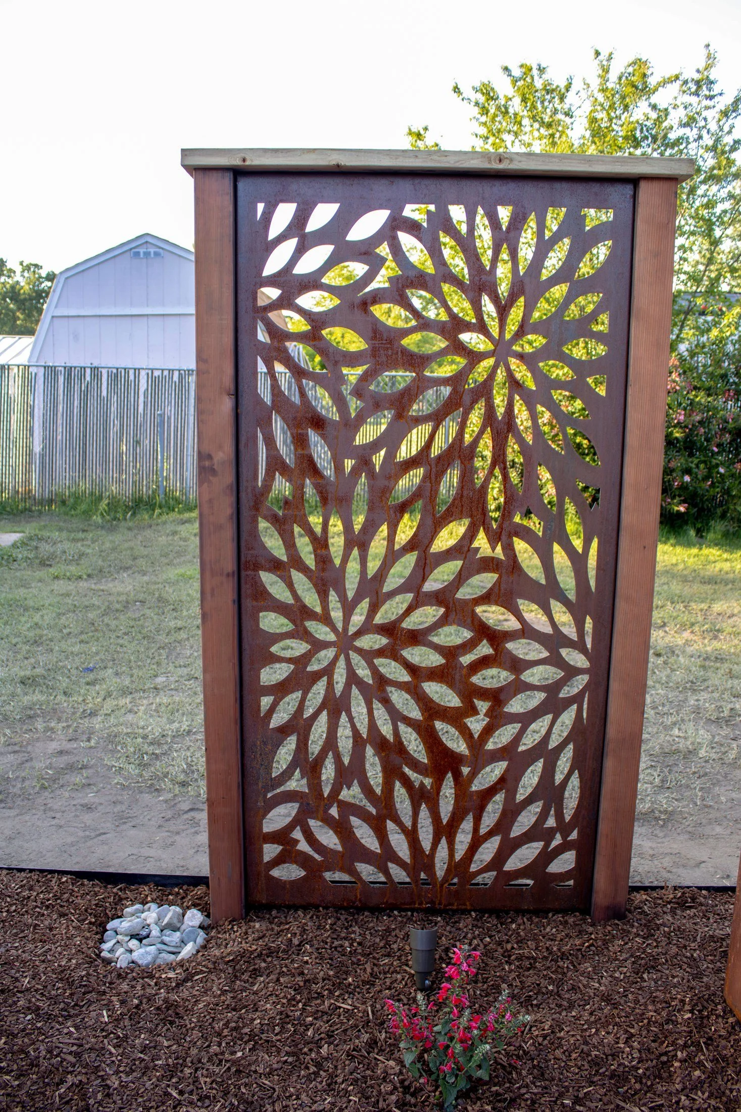 A signature Palmatum laser cut Corten steel privacy panel, weathered to a warm patina.