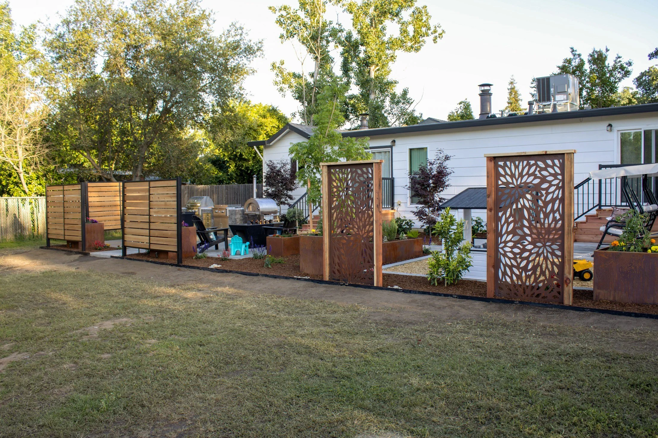 After: cedar and steel privacy screens and laser cut Corten panels define the new outdoor living space.