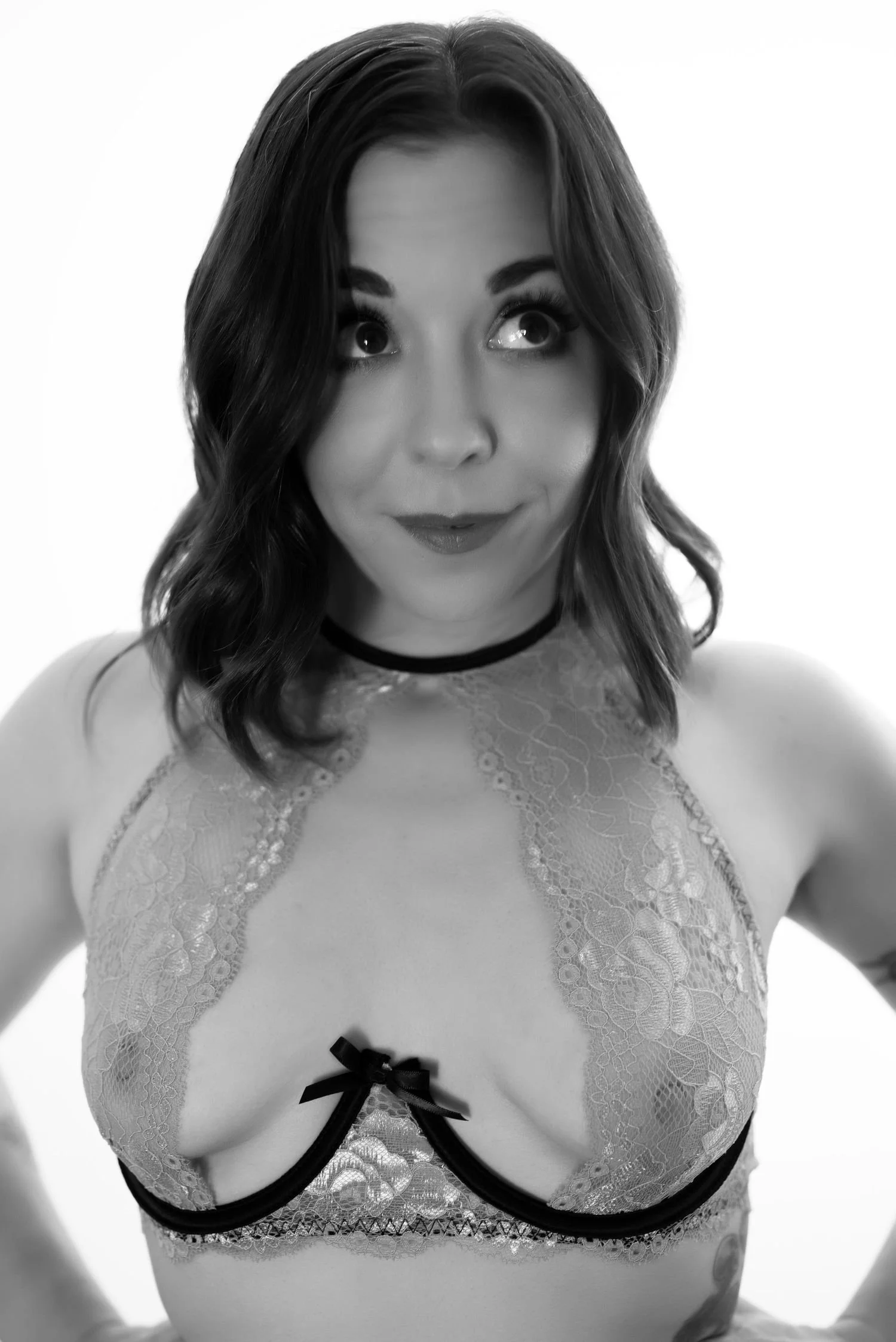 Black and white photo of a woman with medium-length hair wearing a lace top.