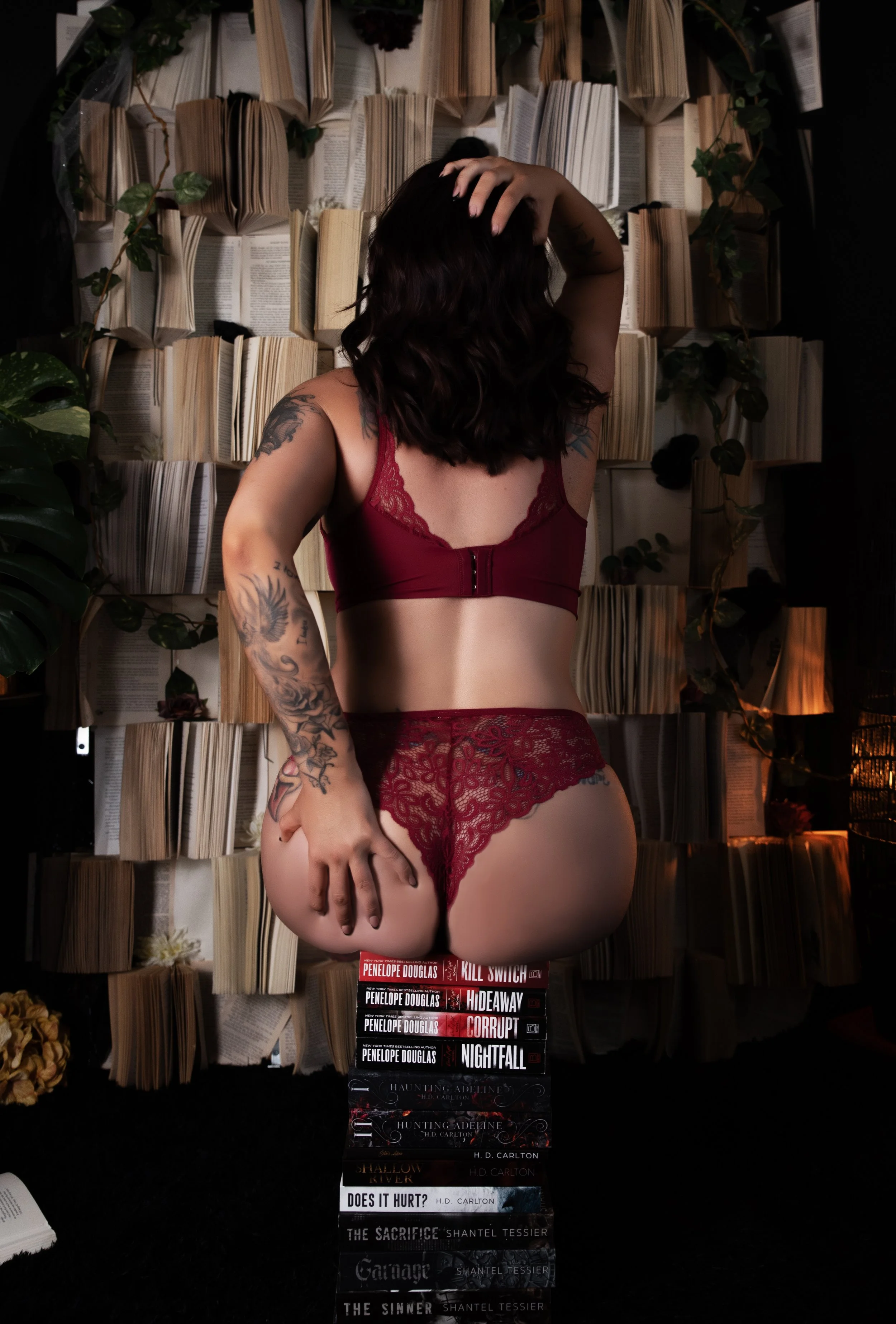 Woman in lingerie sitting on a stack of books for a booktok-inspired photography session at a boudoir photography studio in Crown Point Indiana