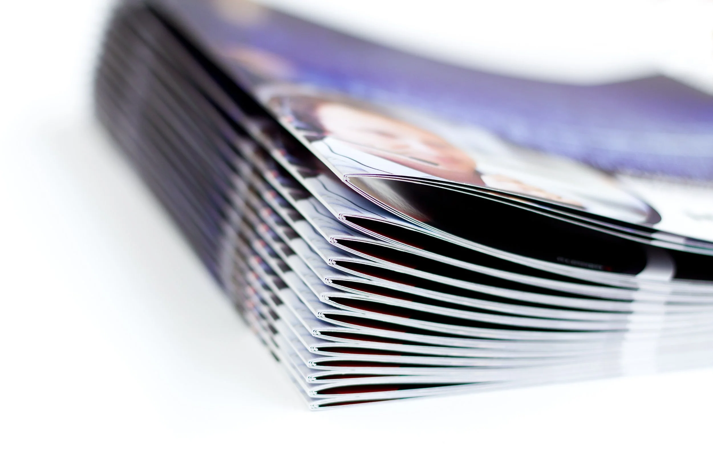 a stack of printed magazines on a white background