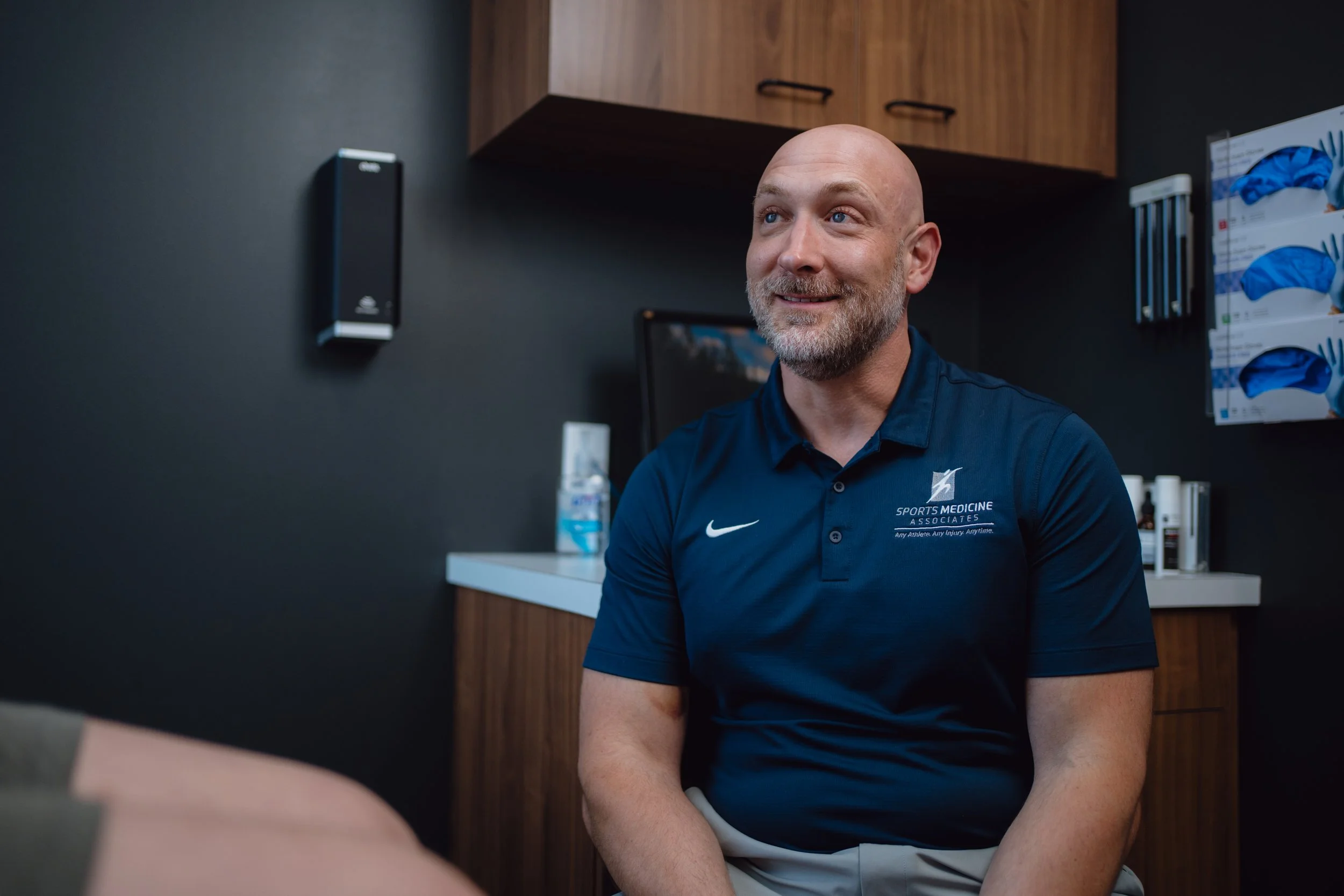 Dr. Jeremy Rush performing a shoulder exam for a young athlete at his San Antonio sports medicine clinic.