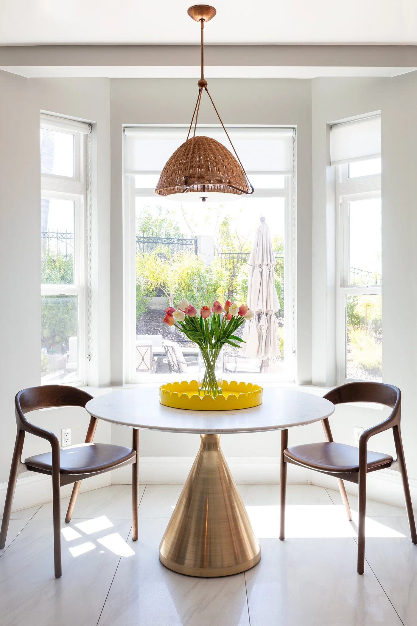 A dining nook with a yellow tray for a pop of color, kitchen decor, marble top table