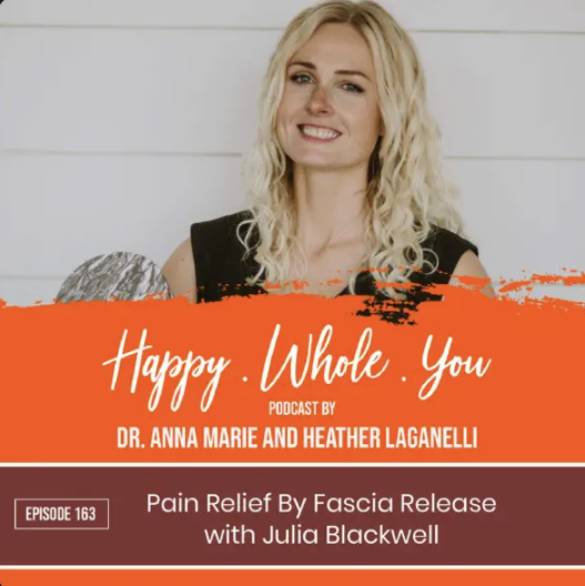 A smiling woman with curly blonde hair, wearing a sleeveless black top, standing against a white wooden background, with an overlay text promoting the "Happy Whole You" podcast episode about fascia release pain relief.