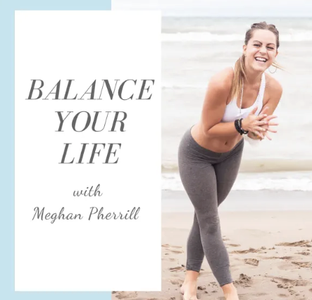 A smiling woman on the beach wearing athletic clothes, holding her hands together, and leaning slightly forward.
