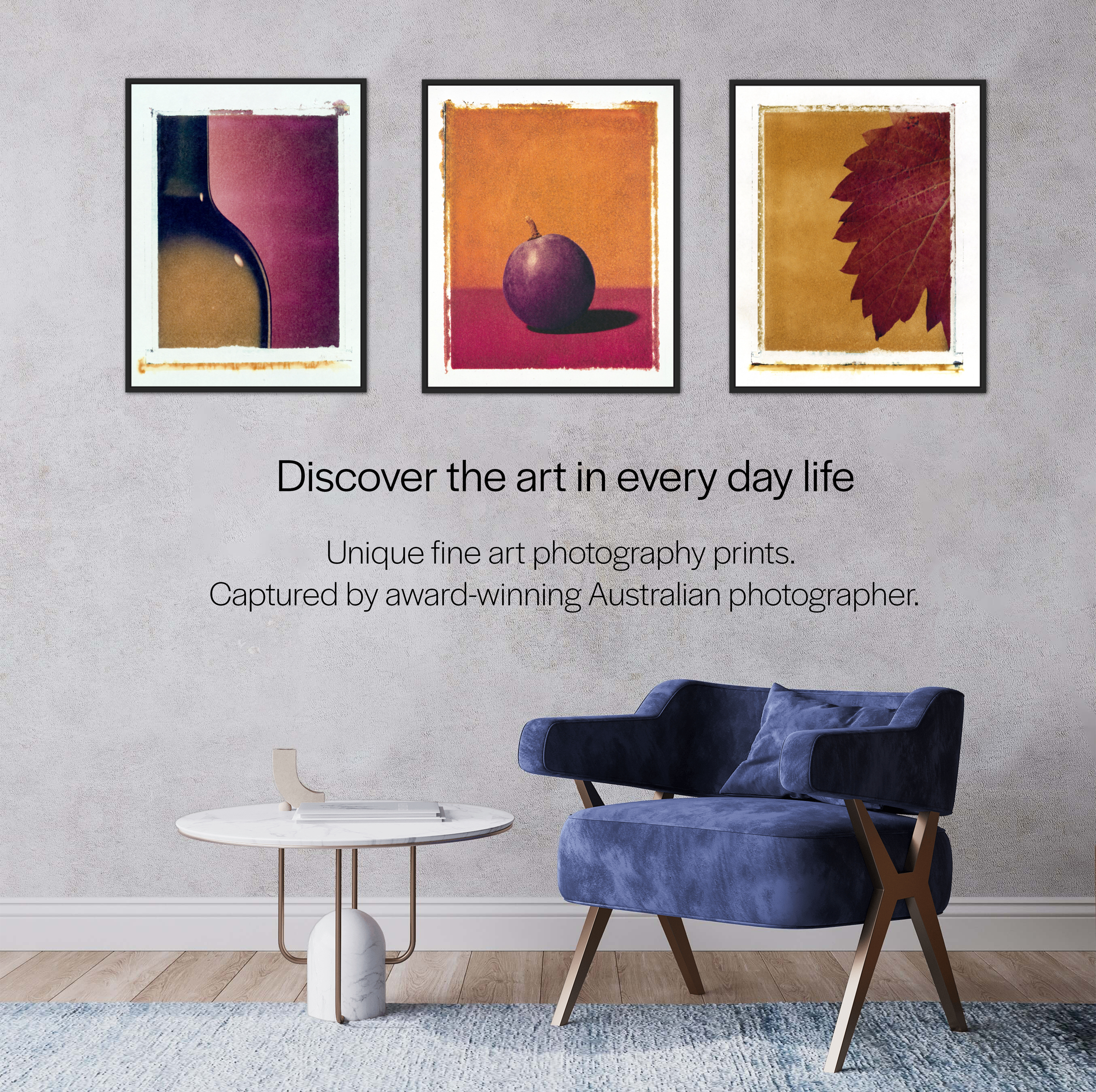Gallery wall with three art prints featuring abstract and still life images, blue velvet armchair, white round side table, and a light-colored rug.