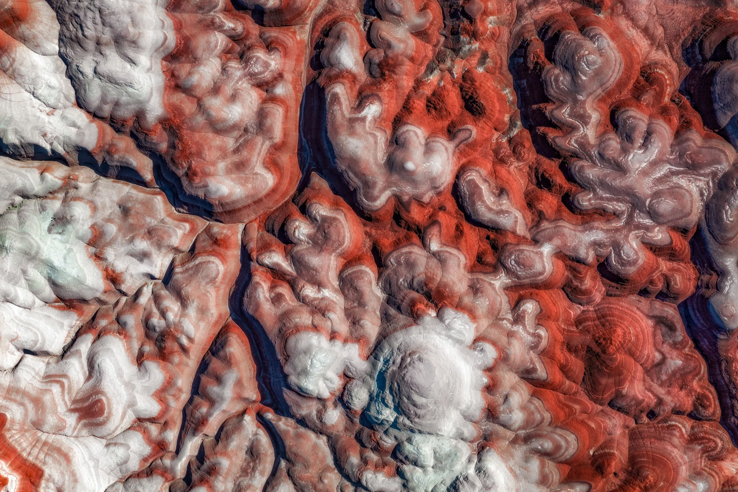 Aerial abstract of the red and white banded swirls of the Bentonite Hills near Hanksville, Utah.