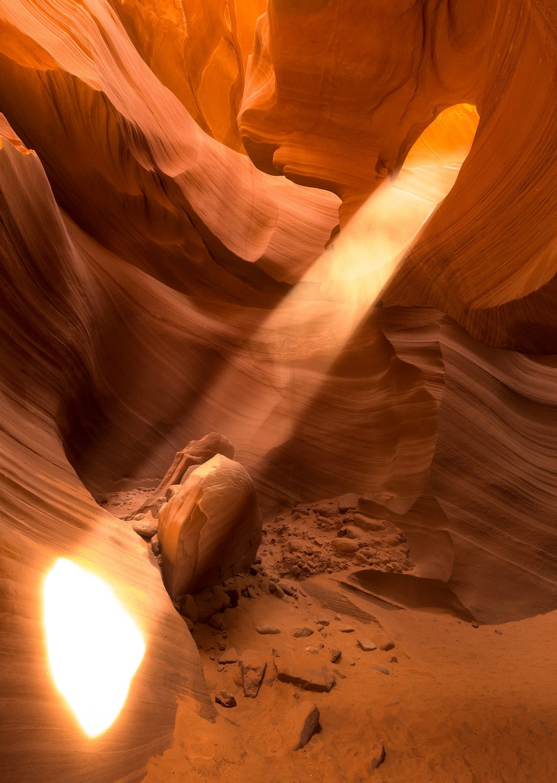 A shaft of sunlight drops through the sculpted sandstone curves of Antelope Canyon, Page, Arizona.