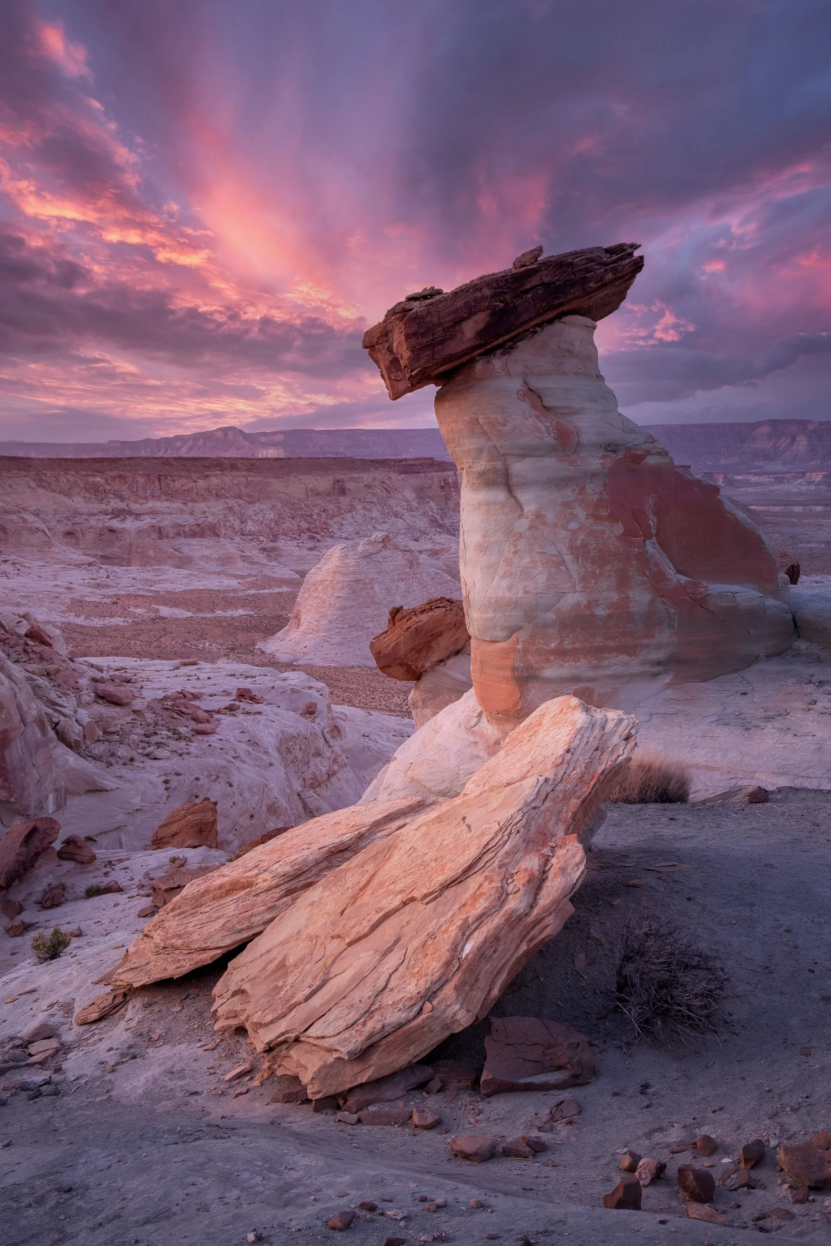 A capstone hoodoo stands against a pink and purple sunset at Stud Horse Point near Page, Arizona.