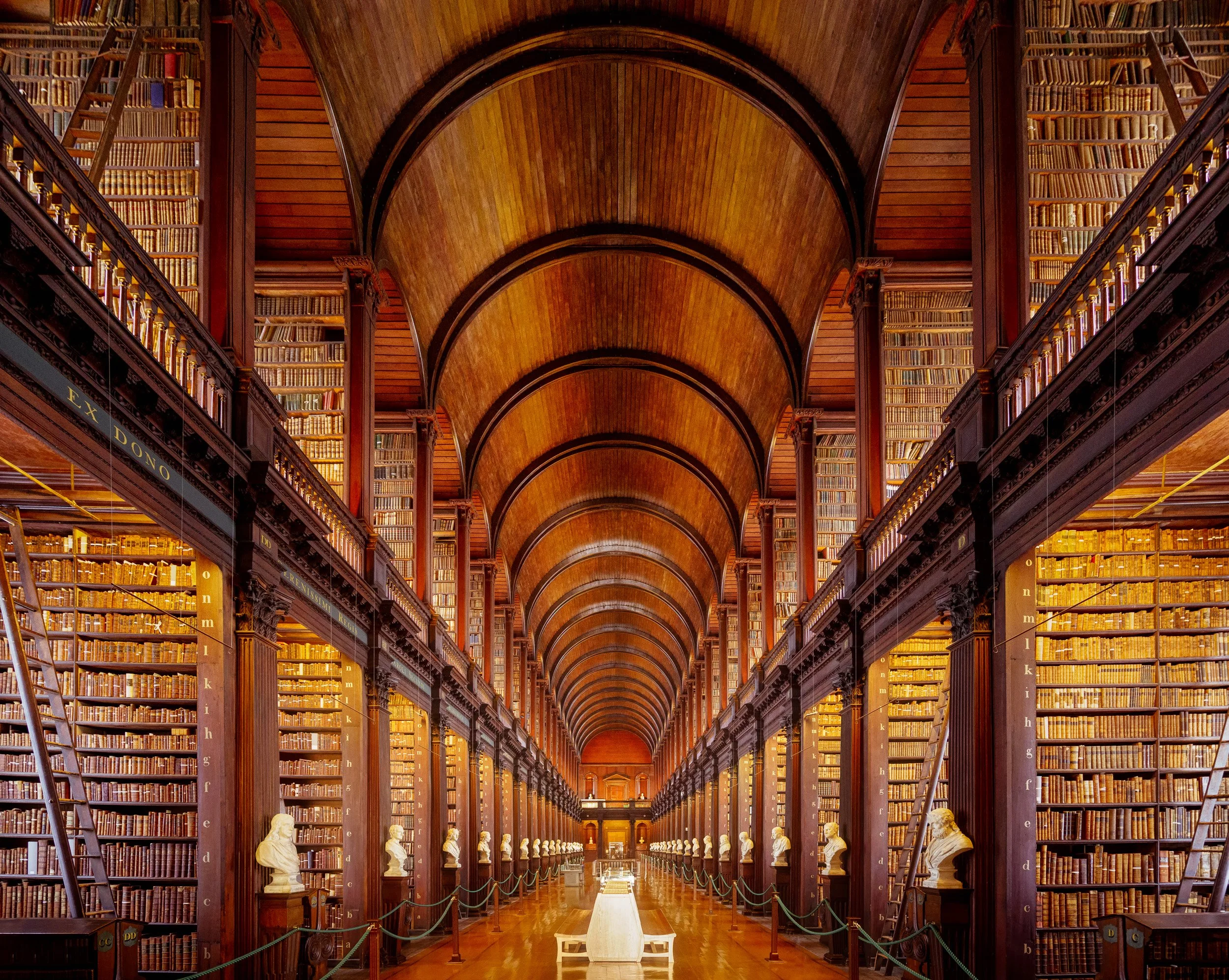 The barrel-vaulted Long Room of Trinity College Library, lined with two storeys of old books and marble busts, Dublin, Ireland.