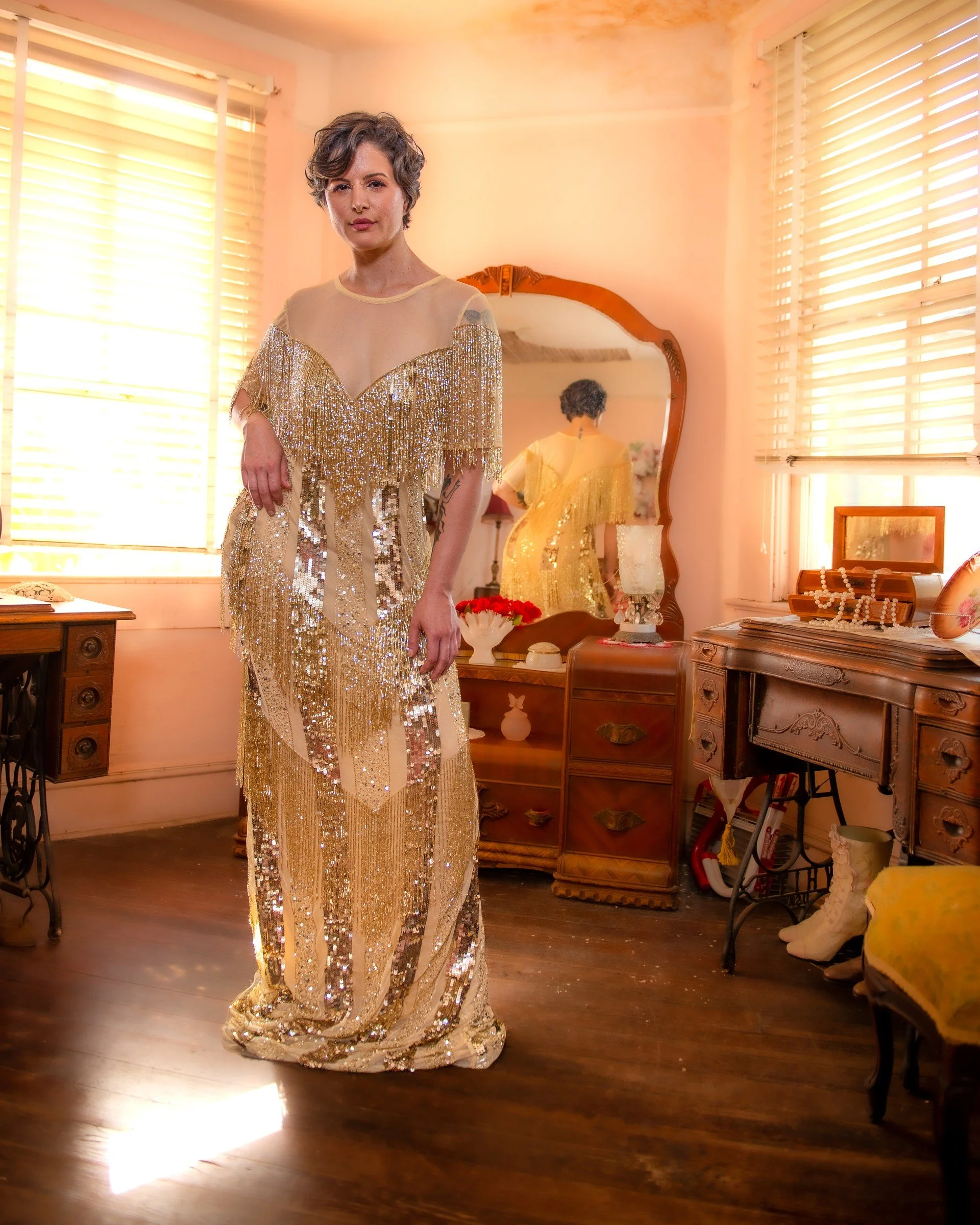 Fashion portrait of a model in a gold Aurelia Batista gown in a furnished interior. Photography by Zech Browning.