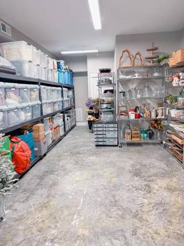 Shelves filled with storage bins and decorative items in a well-organized room, possibly a storage or craft room.
