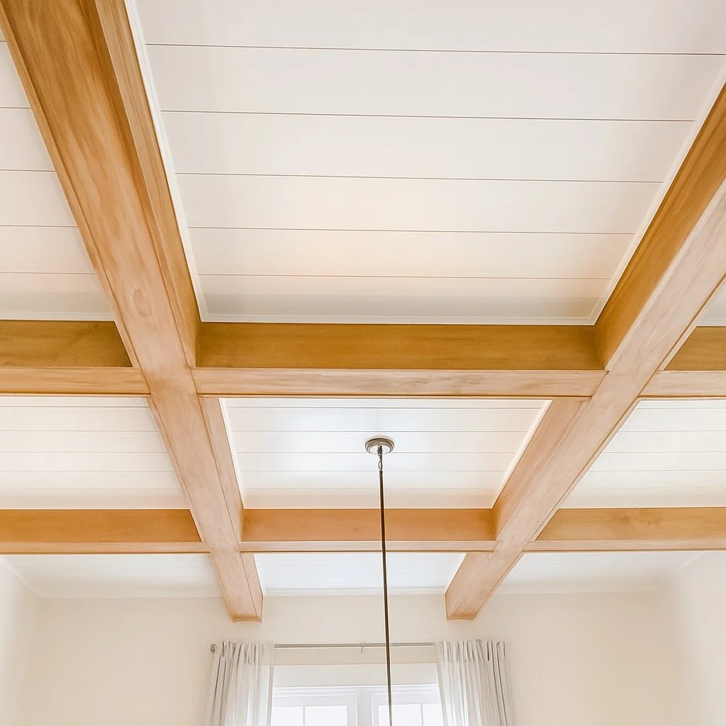 Ceiling with wooden beams and white panels, a hanging light fixture, and curtains in a room