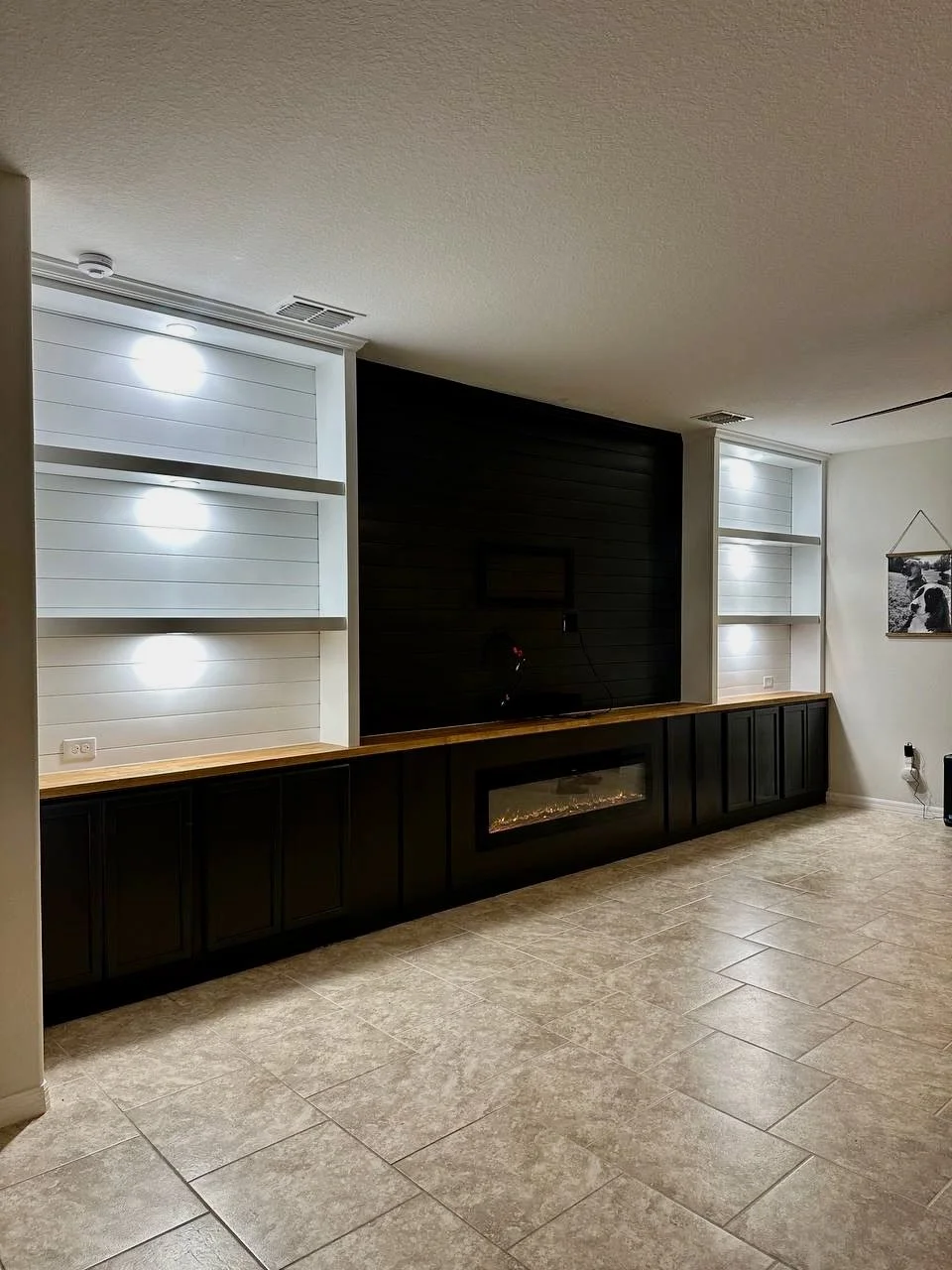 Electric fireplace integrated into custom media wall cabinetry in Bradenton Florida