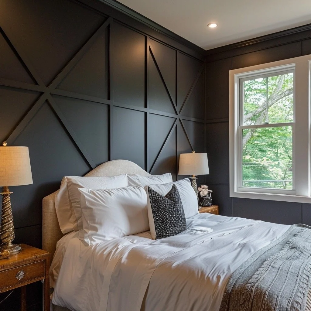 A bedroom with a bed, white bedding, and dark paneled walls. There are two lamps on wooden nightstands on either side of the bed and a window showing green trees outside.