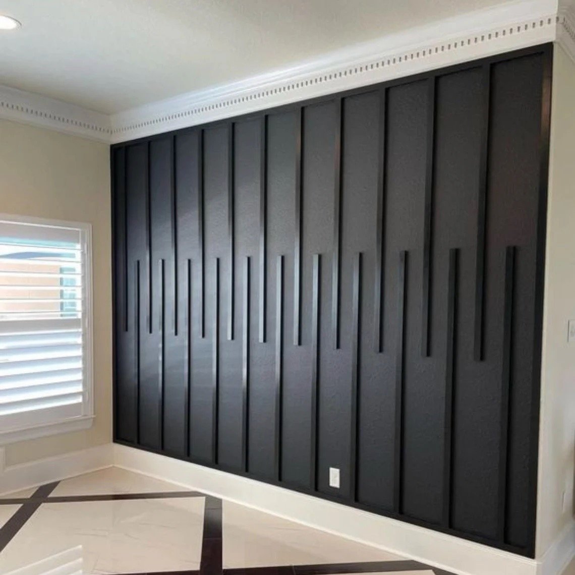 A decorative black wall panel with vertical slats in a modern interior room.
