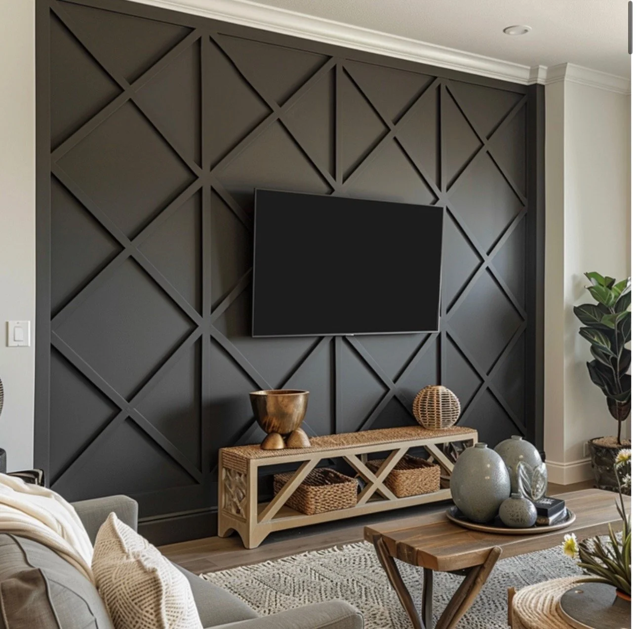 Living room with a black accent wall featuring a geometric pattern, mounted flat-screen TV, wooden console with decorative items, and surrounding furniture and plants.