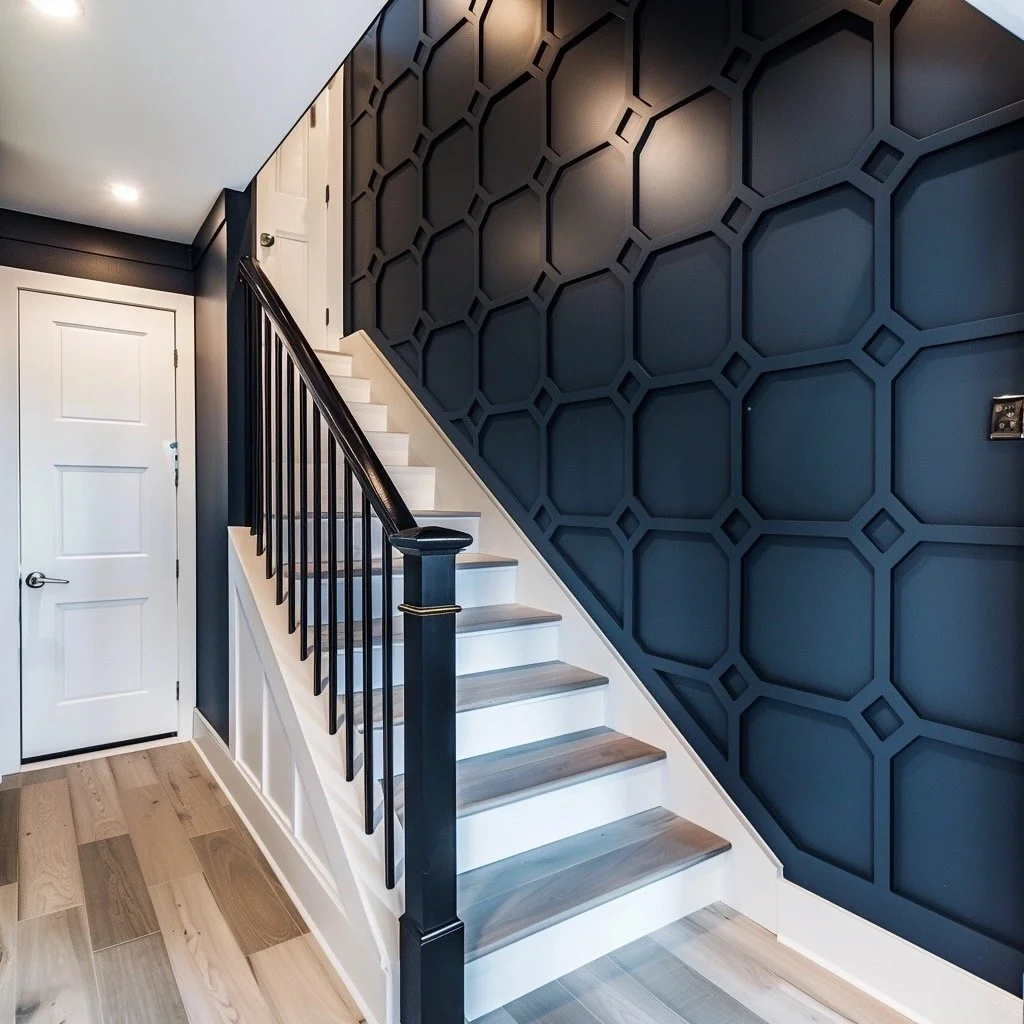 Interior view of a staircase with white risers, gray treads, black handrail, and black spindles. The wall beside the stairs has a blue geometric pattern. There is a white door at the bottom of the stairs.