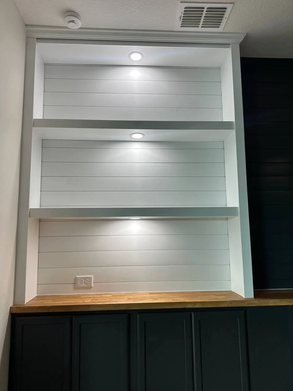 Built-in shelving niches with integrated lighting and shiplap backing in Bradenton FL