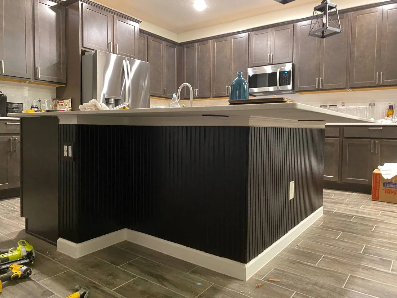 Modern kitchen island with vertical wood slat accent finish carpentry