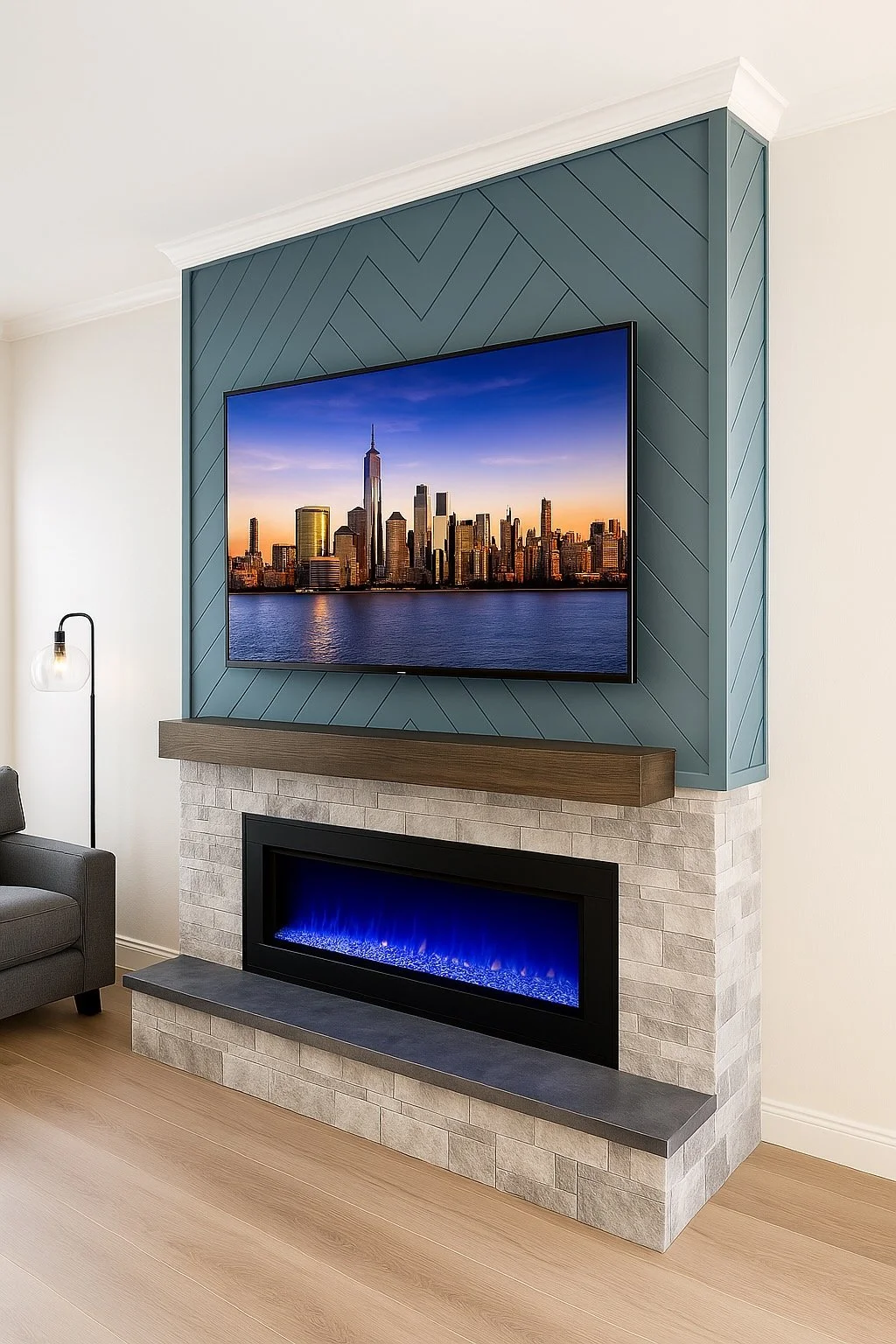 Living room with a wall-mounted flat-screen TV displaying a city skyline at sunset, above a modern fireplace with blue flames, set against a blue accent wall with geometric paneling.