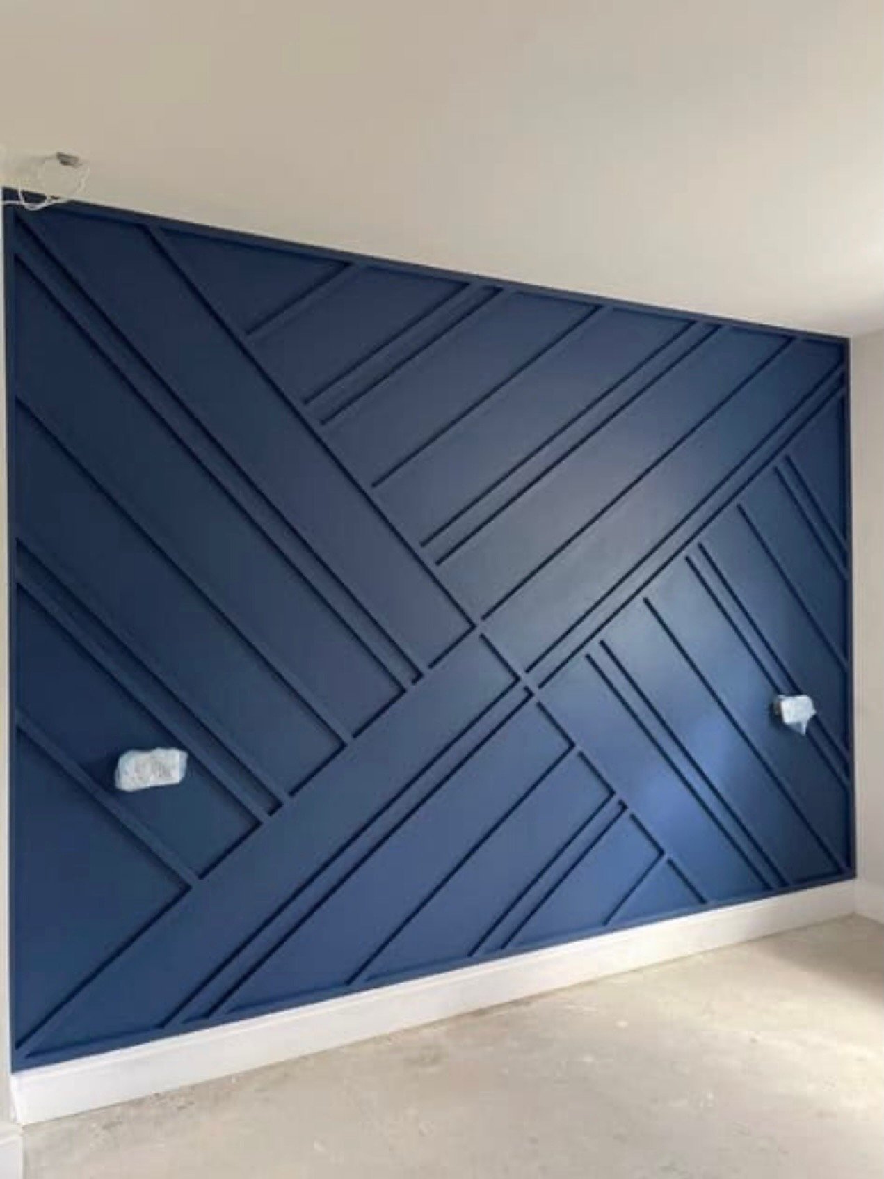 Blue geometric wall panel with diagonal and horizontal wooden planks in a modern interior.