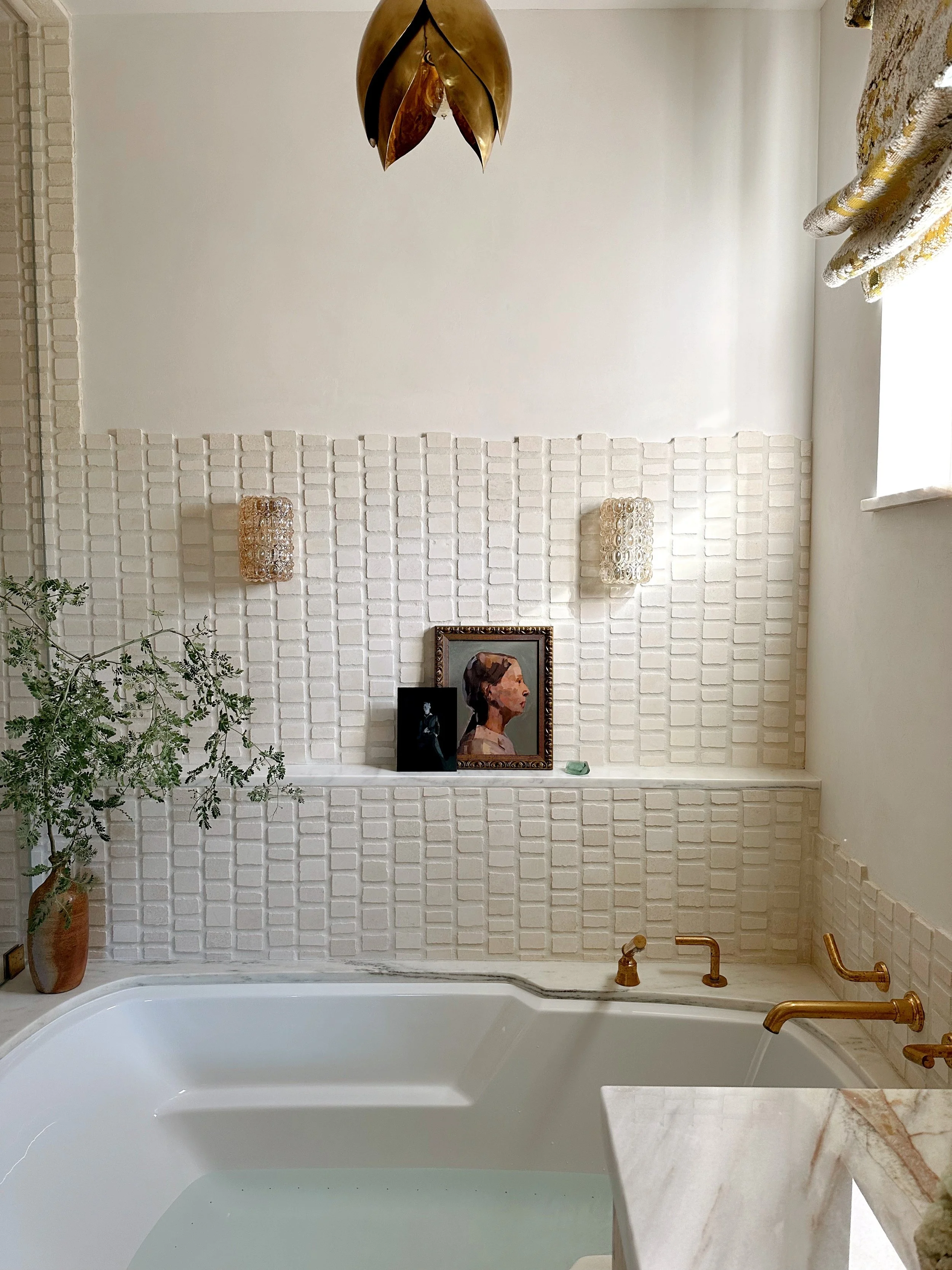 a raw brass faucet fills the spa tub for a deep soak