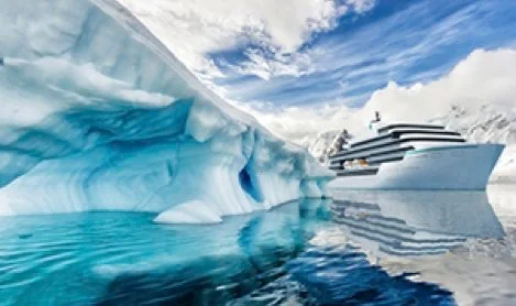 A large cruise ship near floating icebergs in icy waters.