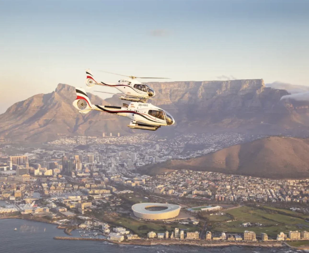 Helicopters flying over Cape Town with table mountain in the background excursion with Pan Am luxury private jet safari