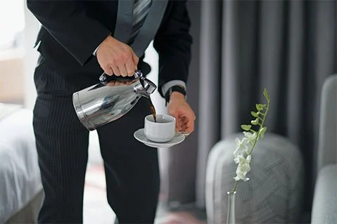 Person pouring coffee into a cup in a modern living room