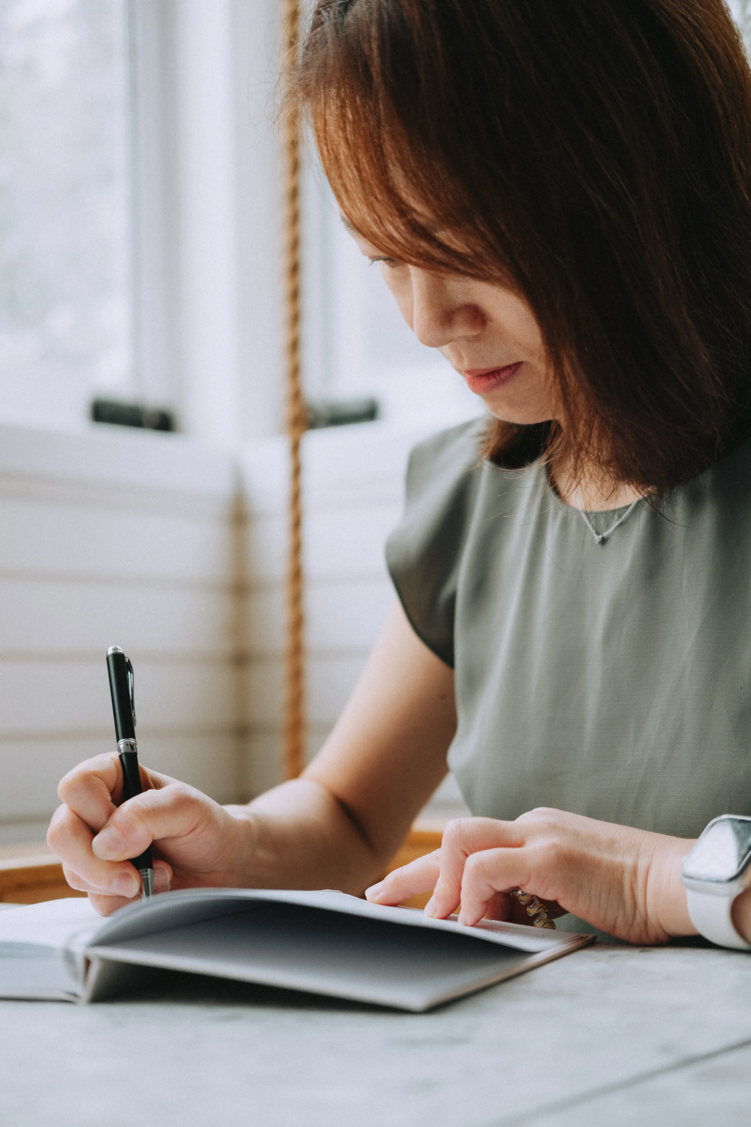Maggie, Founder of Freedompath, looking down and writing in a notebook