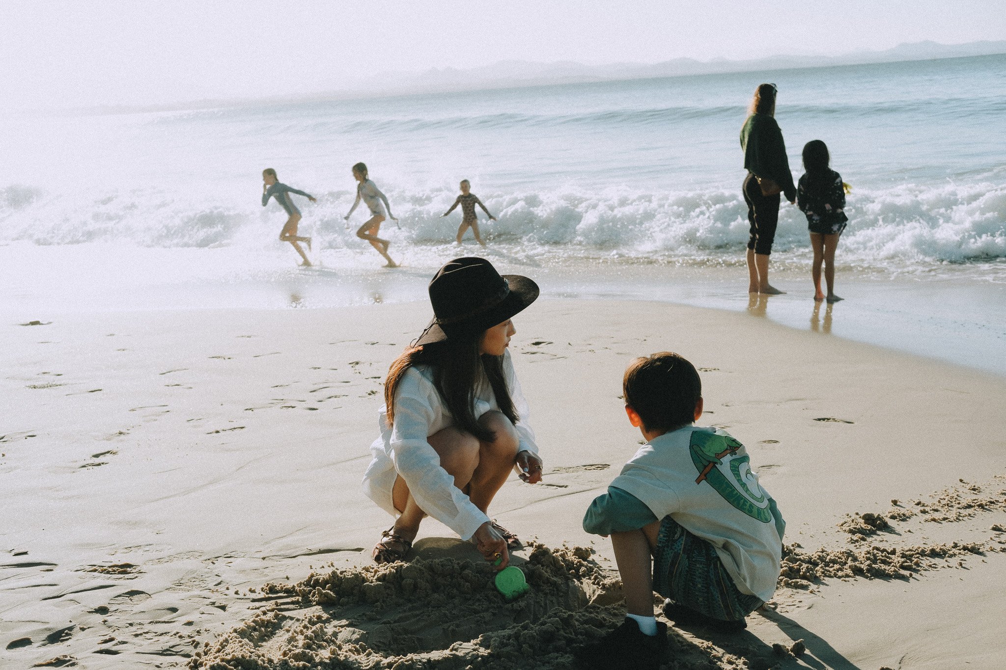 Mum and son playing together in the sand at the shoreline