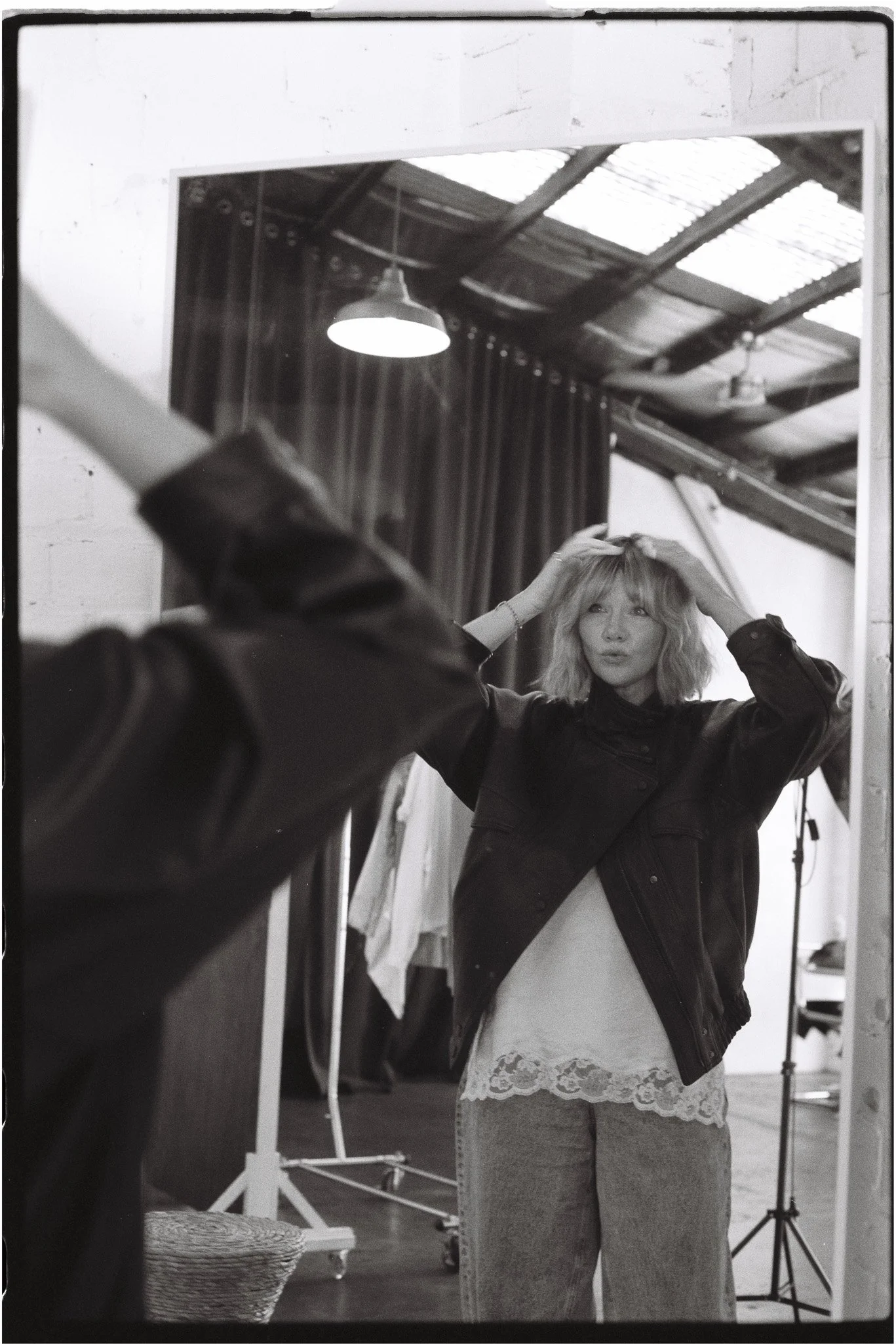 Woman adjusting her fringe in a mirror, inside The Station Brisbane