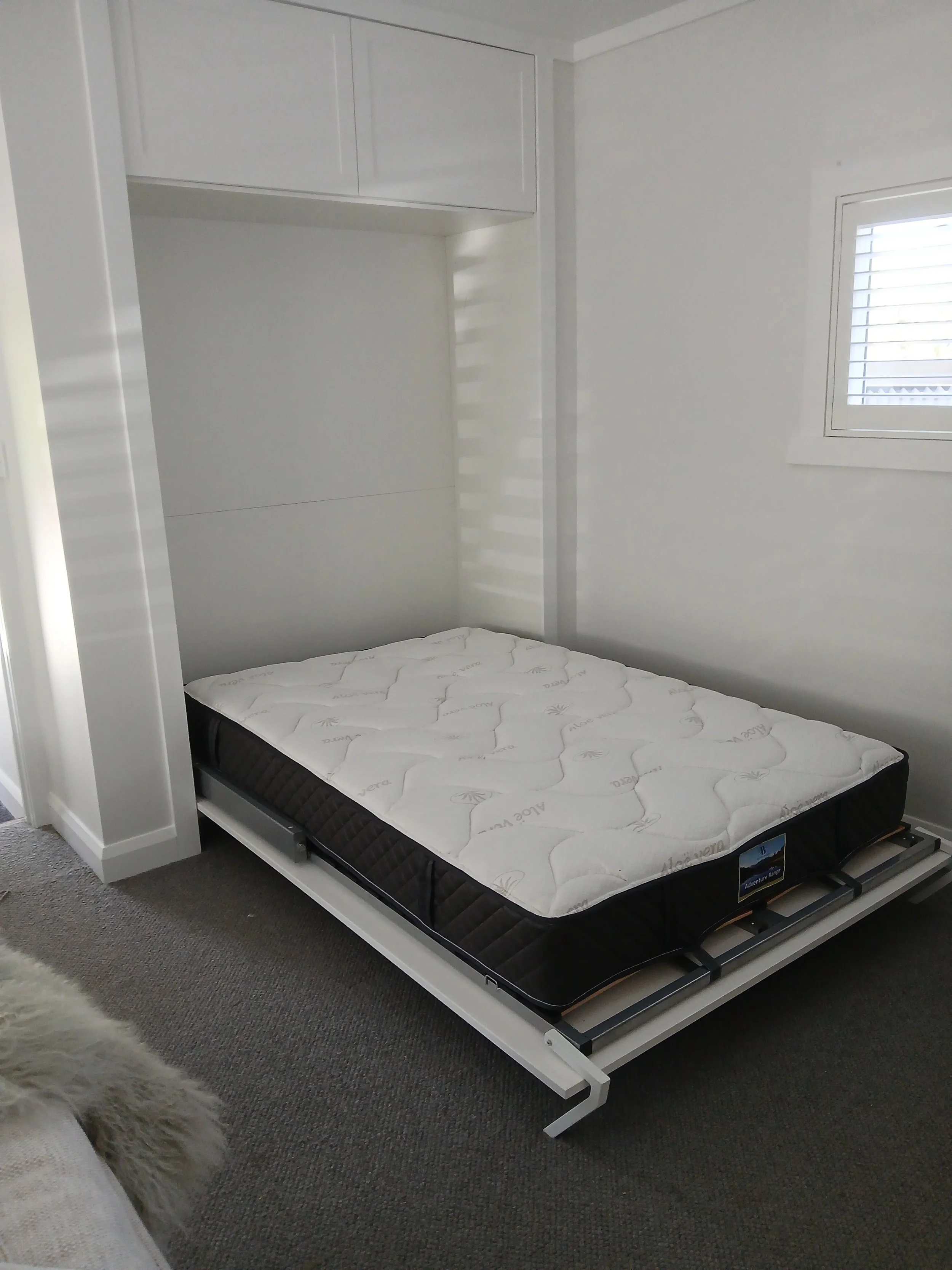 Pull-down bed on show that then can be folded away and look like sleek cabinetry