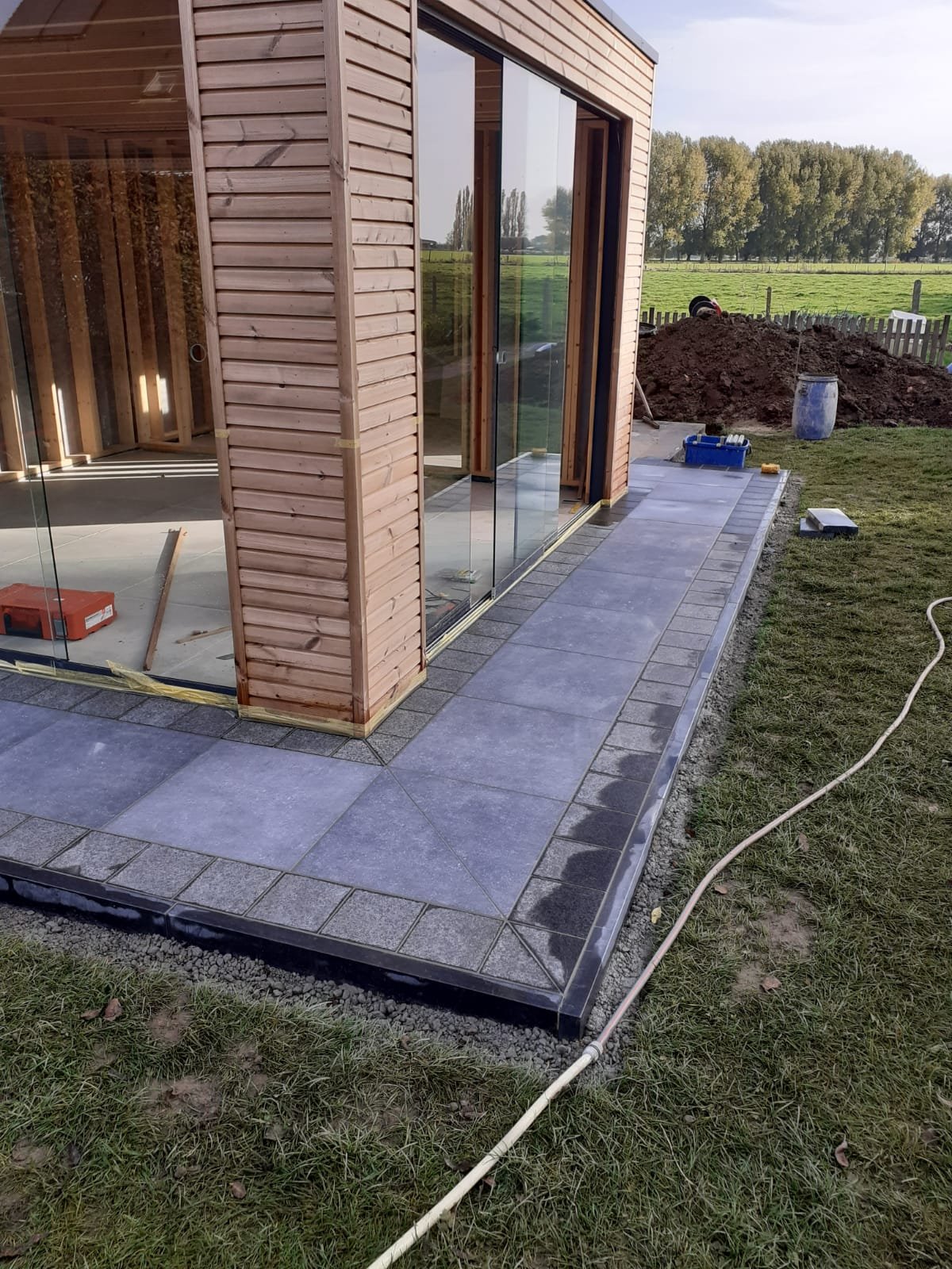 Plaatsing terras rond zelfgeplaatste tuinkamer