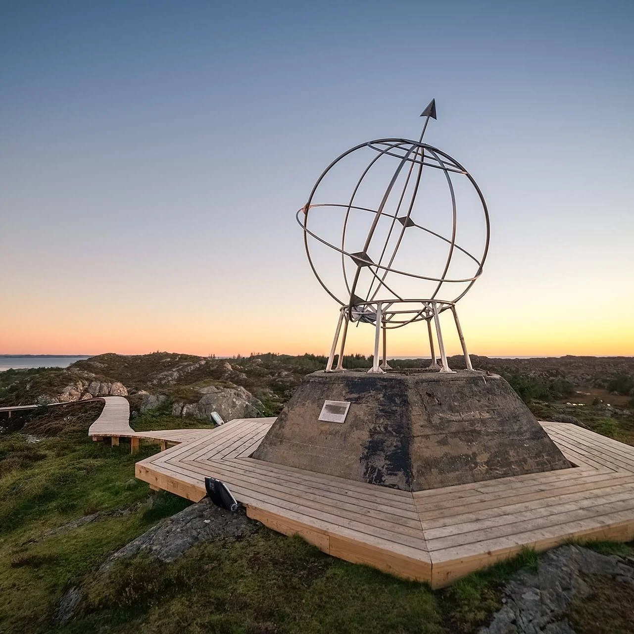 Et futuristisk, grønt opplyst vindtårn står på et betonggrunnlag mot en mørk, stjernenatt.