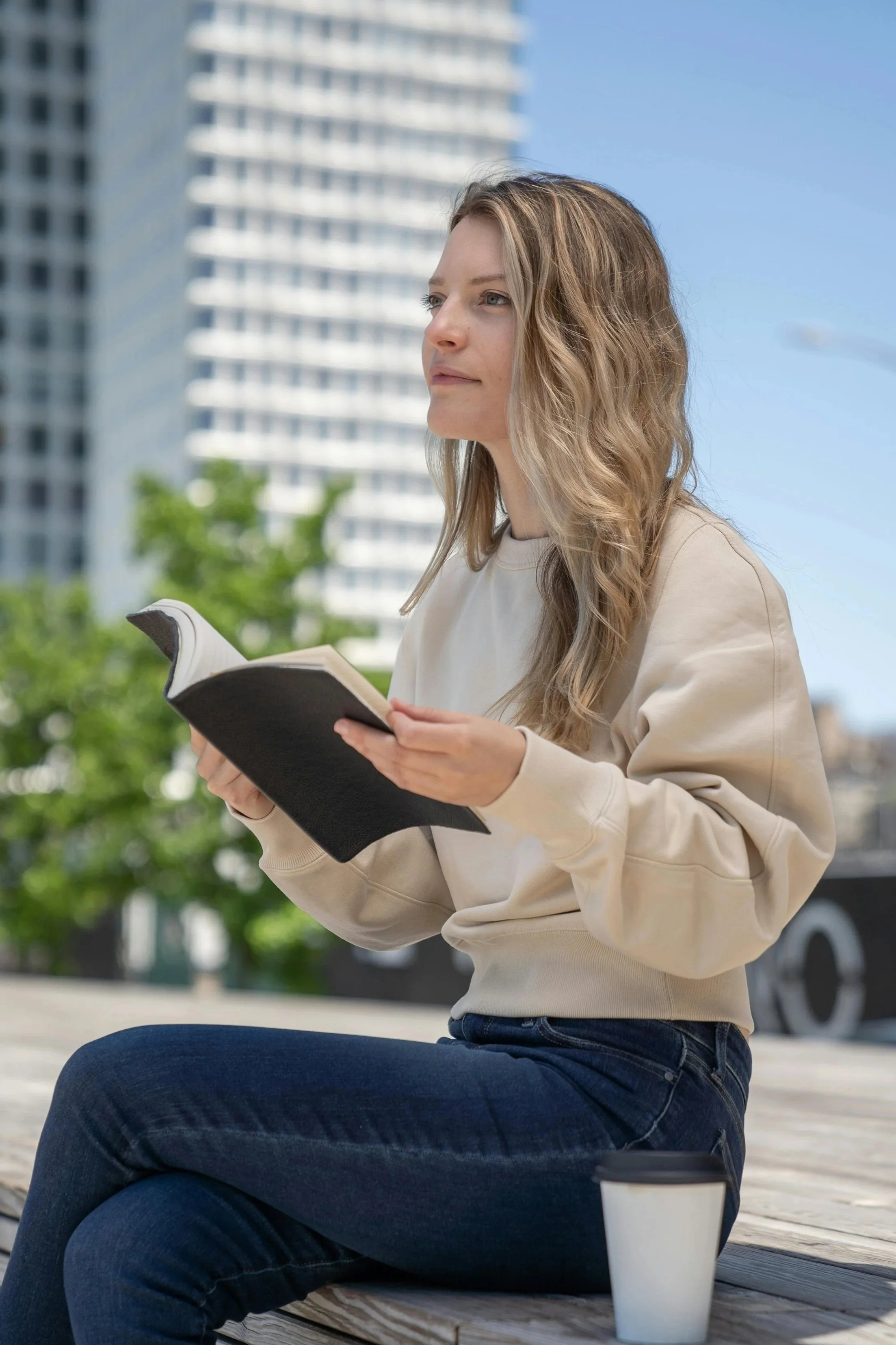 A woman looking at a book outside