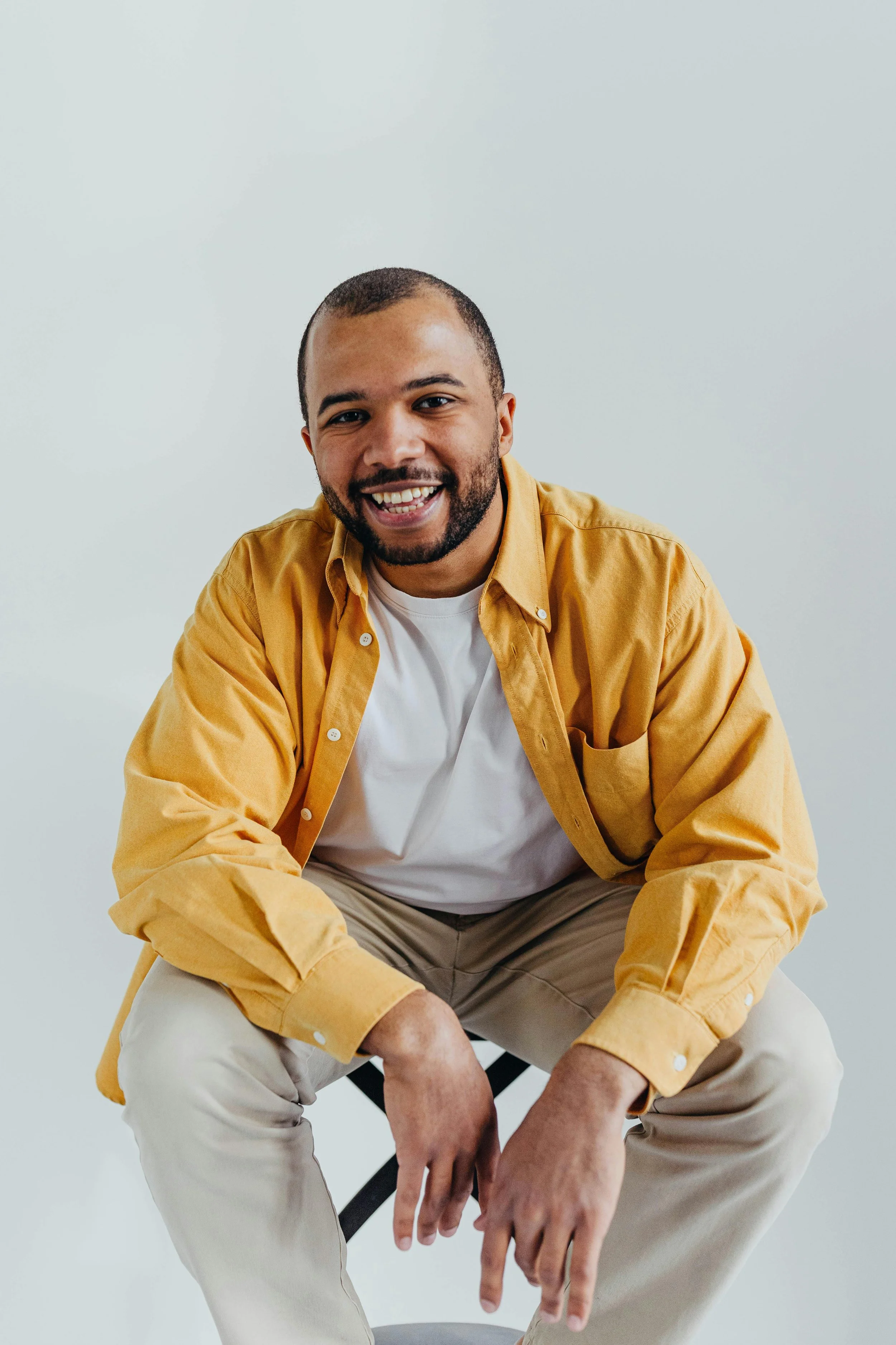 A man wearing an orange shirt smiling