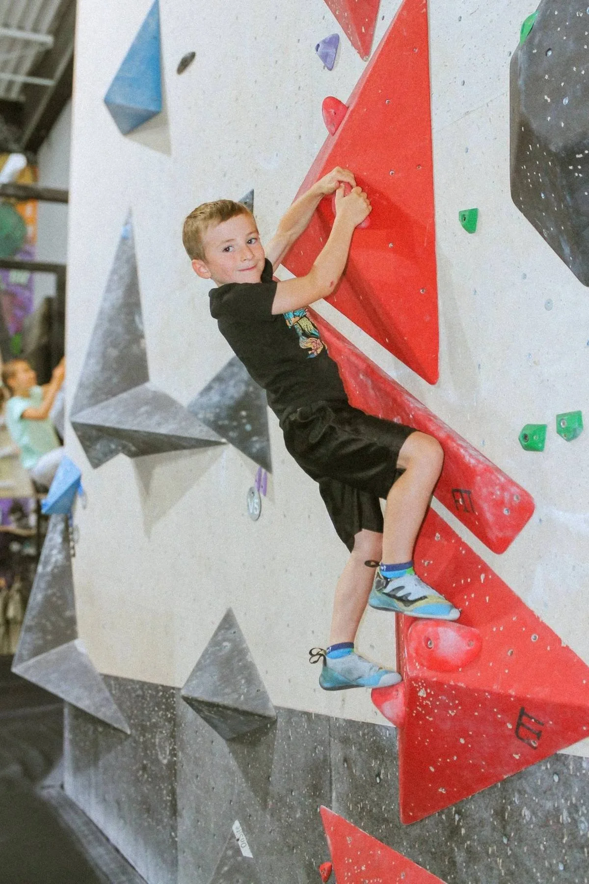 Enfant du camp de jour qui grimpe sur un mur de bloc au Hook à Sainte-Julie