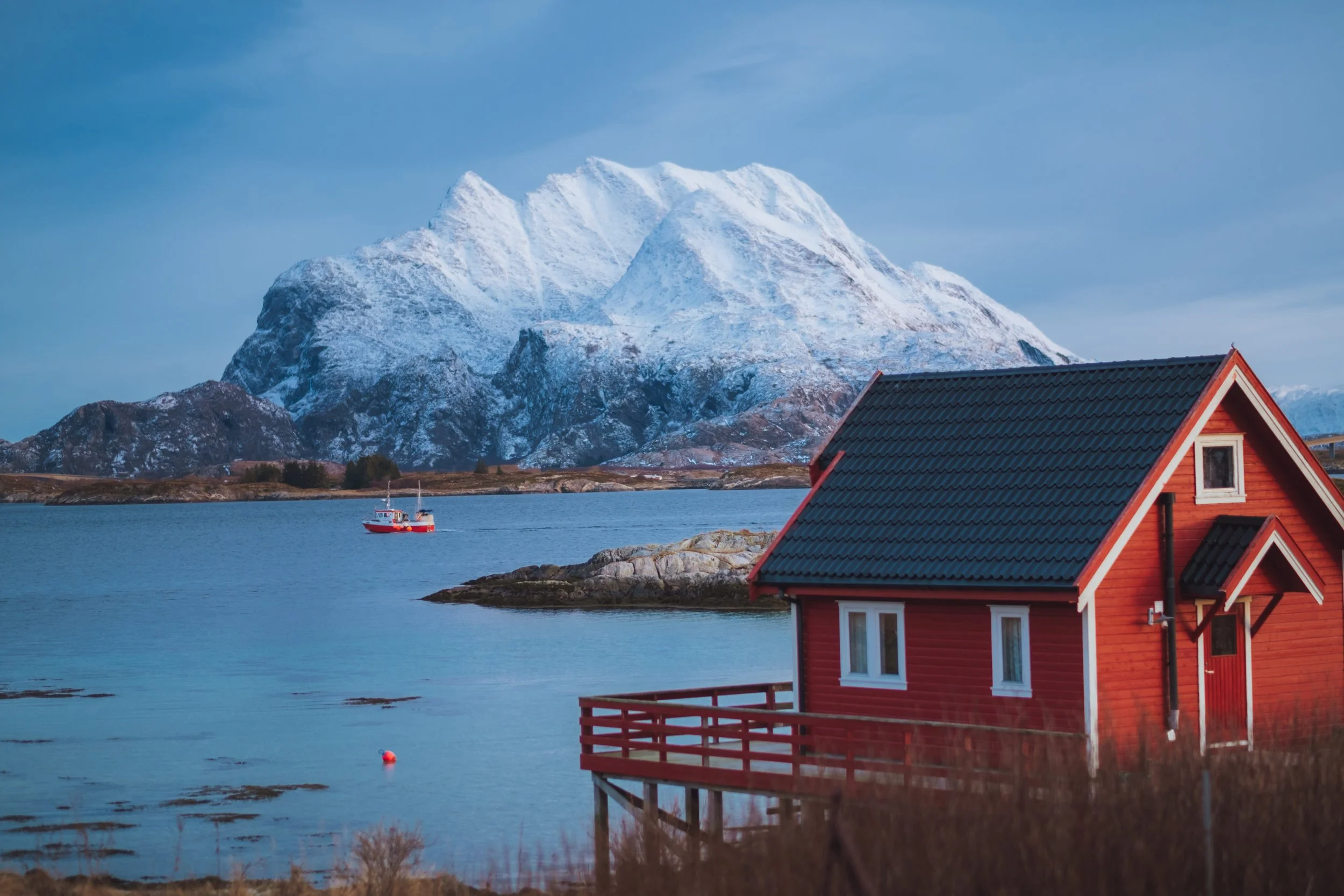Naust og fiskebat med Donnamannen i bakgrunnen_Emilie Solbakken _ Visit Helgeland_19825955 (1).JPG