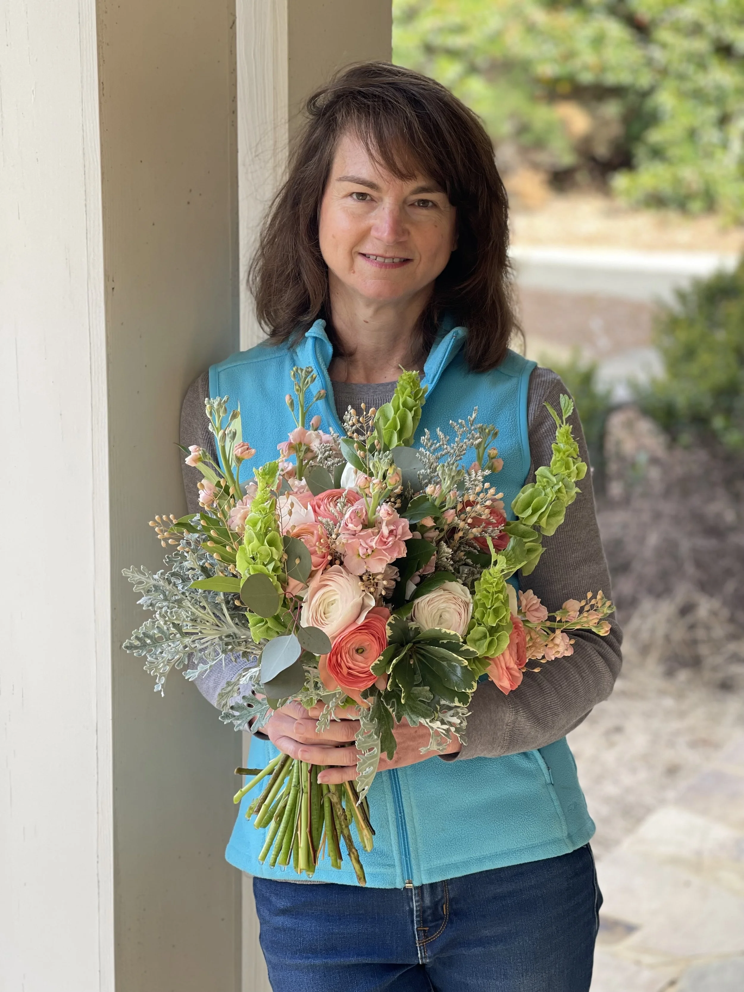 Jennifer Howard from Buck Naked Farm holding a peach winter bridal bouquet