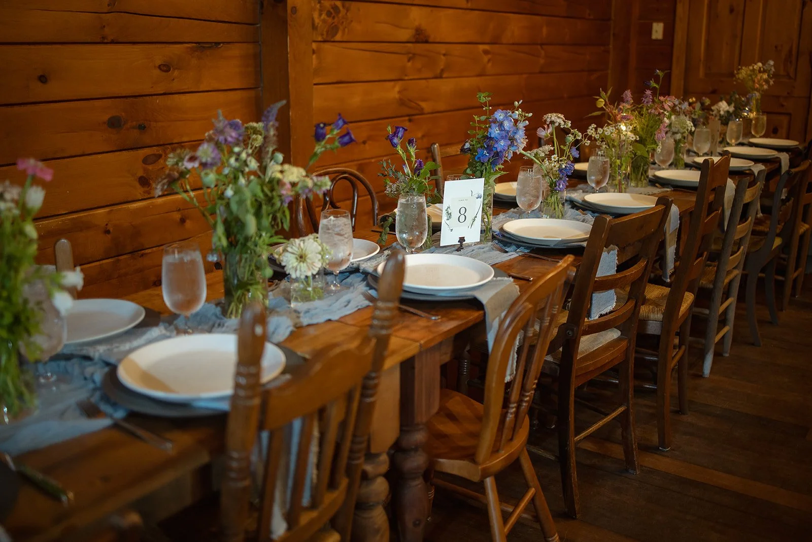 Long reception tables lined with whimsical bud vases at the Barn at Valhalla