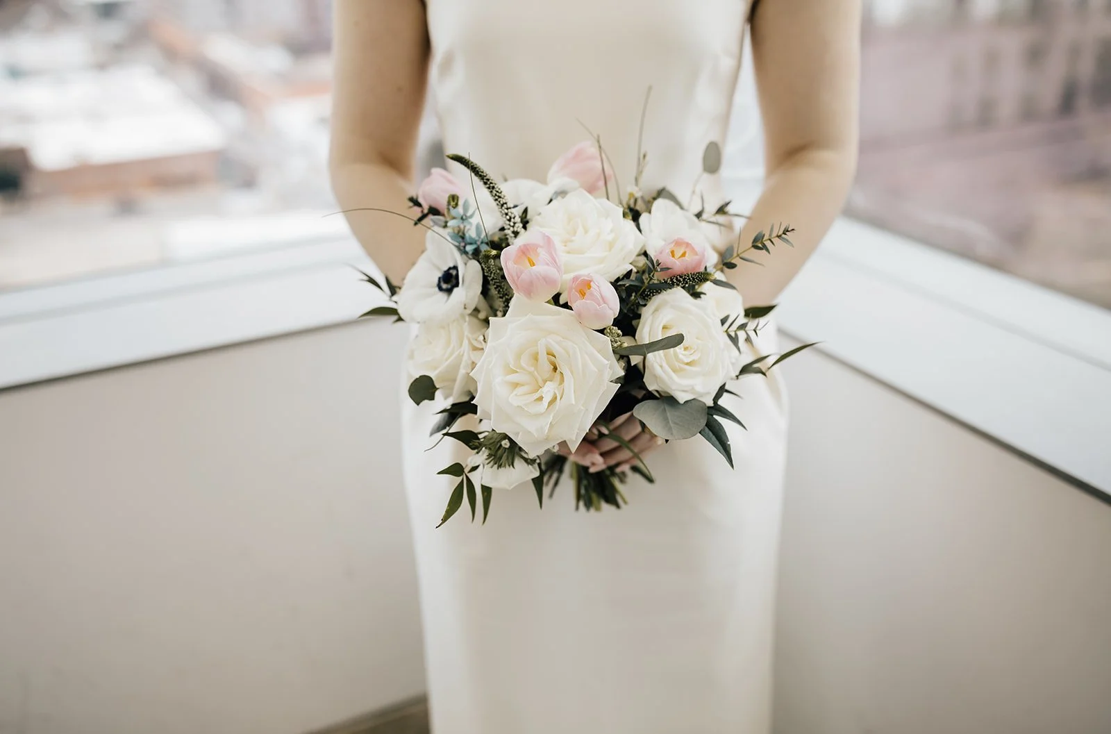 A bride holds a spring pastel wedding bouquet at the raleigh, NC courthouse