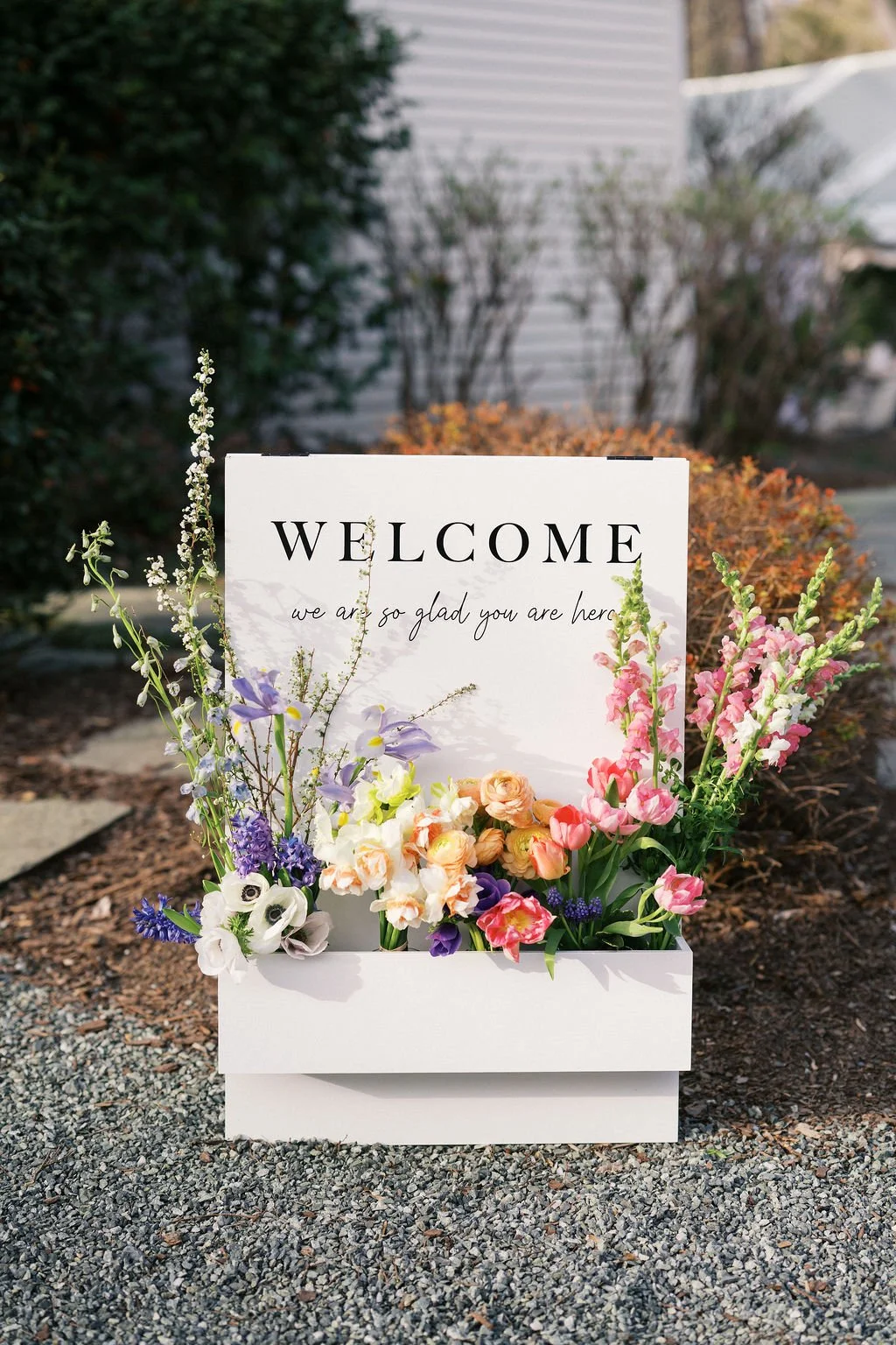 white wedding flower welcome sign with bright spring florals from Chapel Hill wedding florist Hen House Flowers
