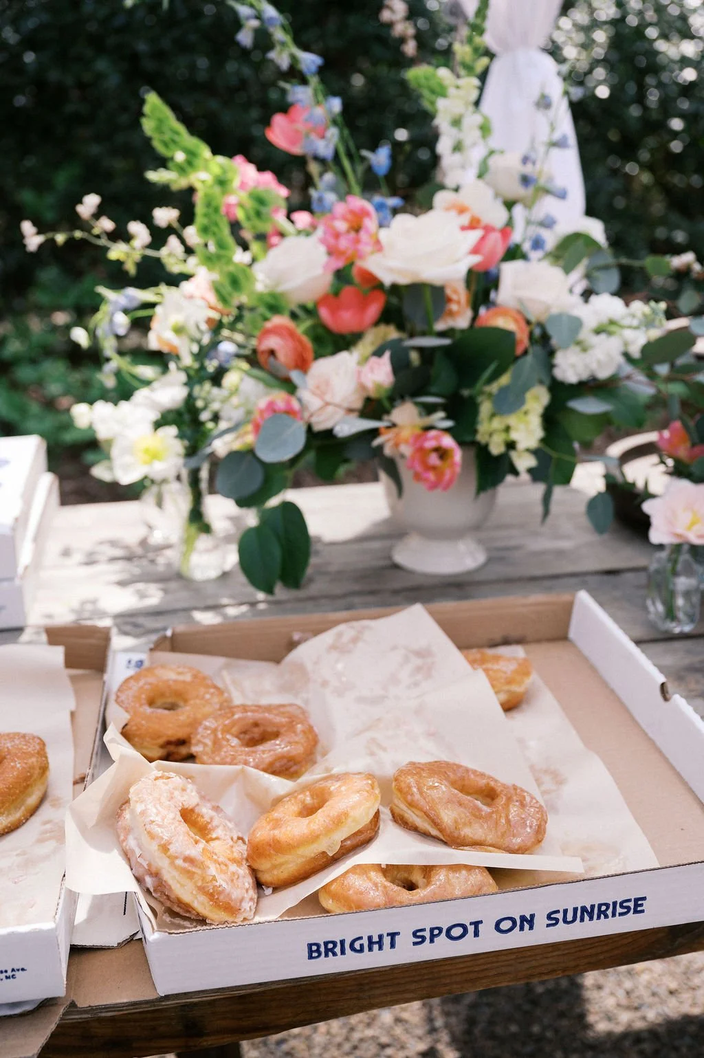 Brunch wedding table with citrus floral arrangement and doughnut box