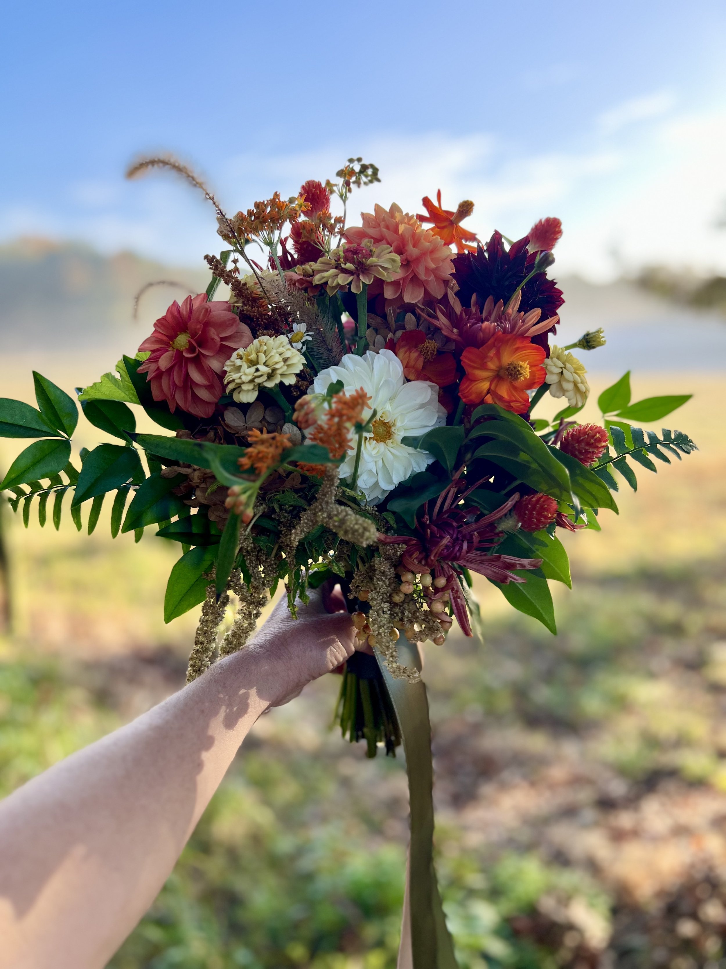 Burnt orange and green NC fall wedding bouquet at Union Grove Farm in Chapel Hill, NC