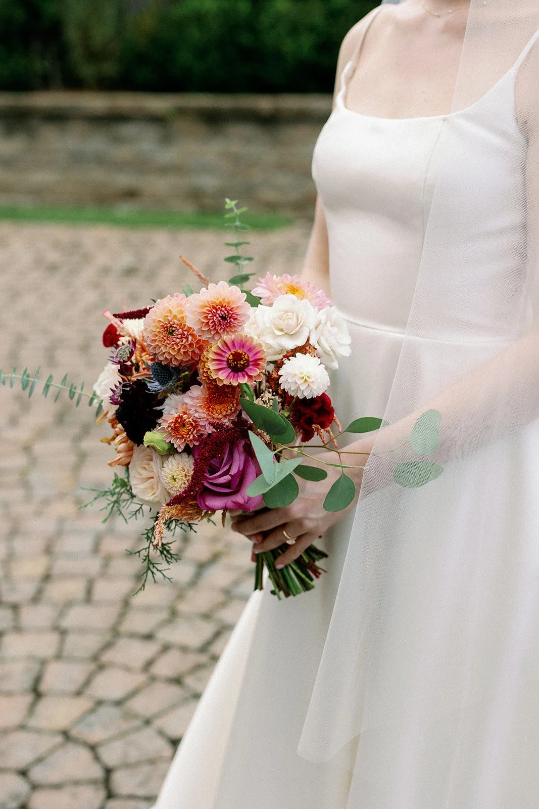 A bride holds a wedding bouquet of dahlias and chrysanthemums from Buck Naked Farm in Pittsboro, NC