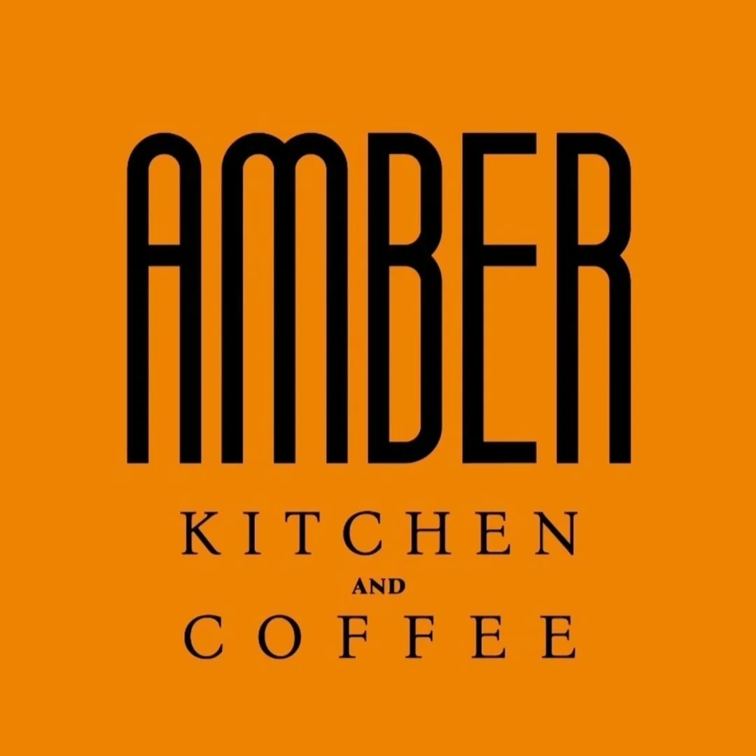 Logo with the text 'Amber Kitchen and Coffee' in black on an orange background.