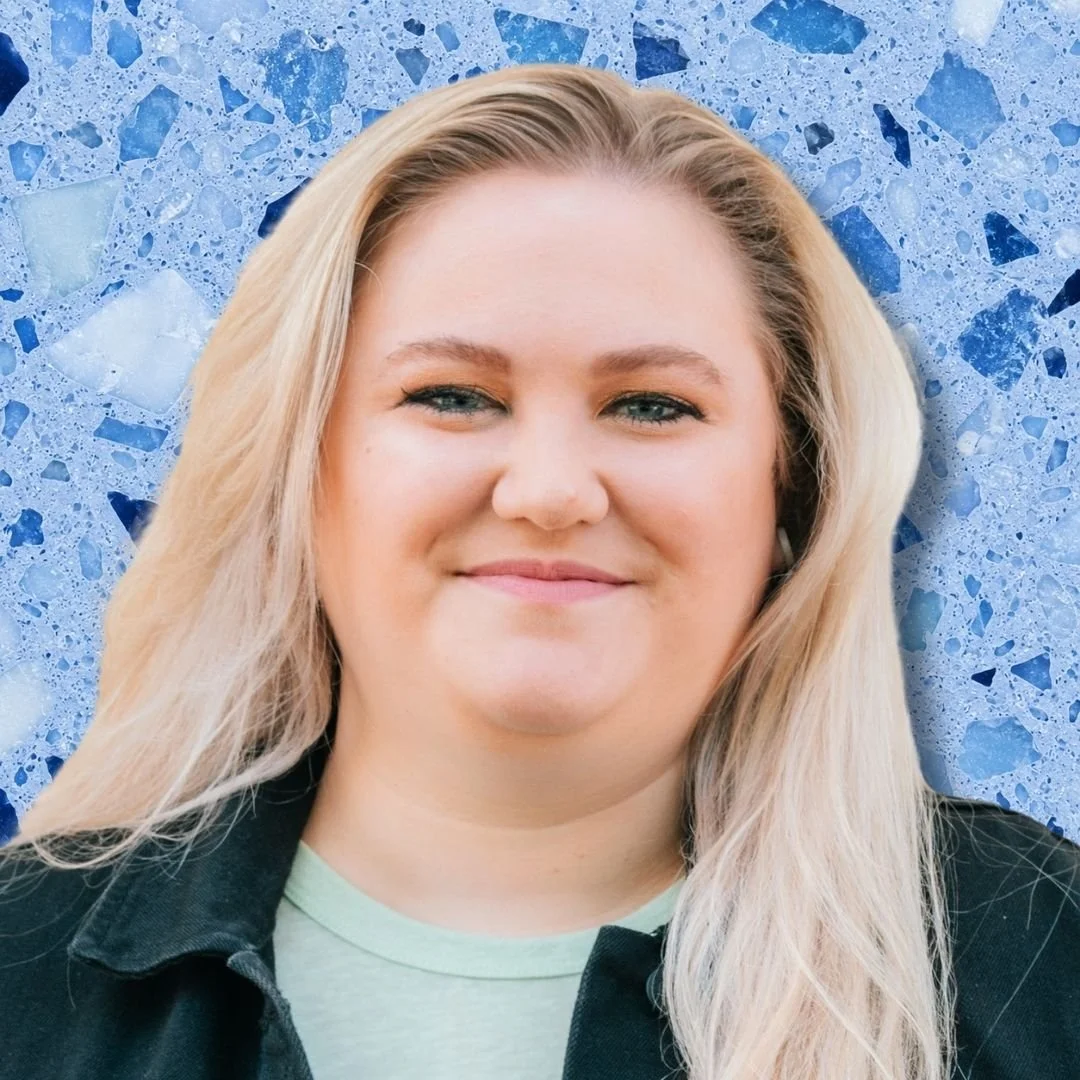 A woman with long blonde hair smiling in front of a blue terrazzo background.